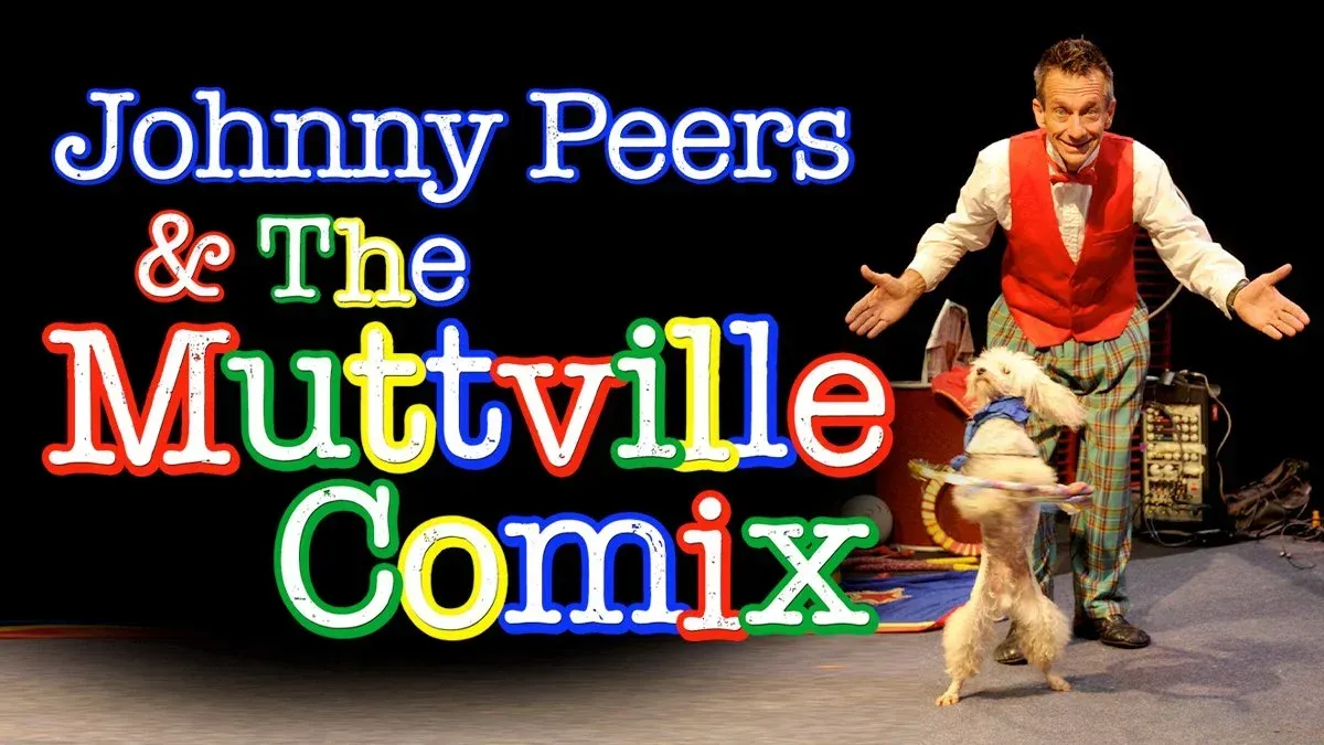 Johnny Peers with a dog, performing a comedy act on stage.