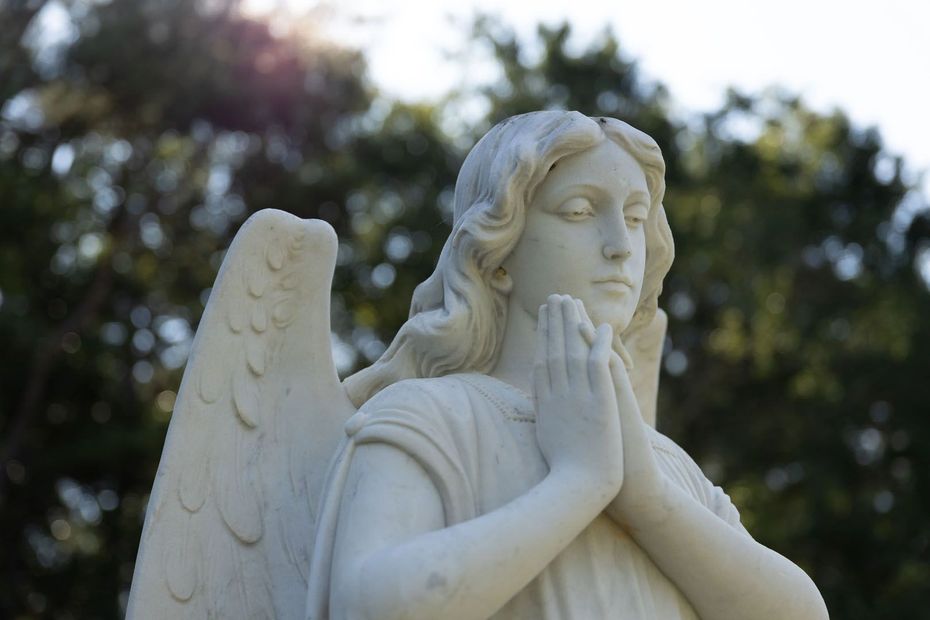 A statue of an angel with her hands folded in prayer