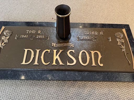 A grave with a hole in the middle and a plaque on top