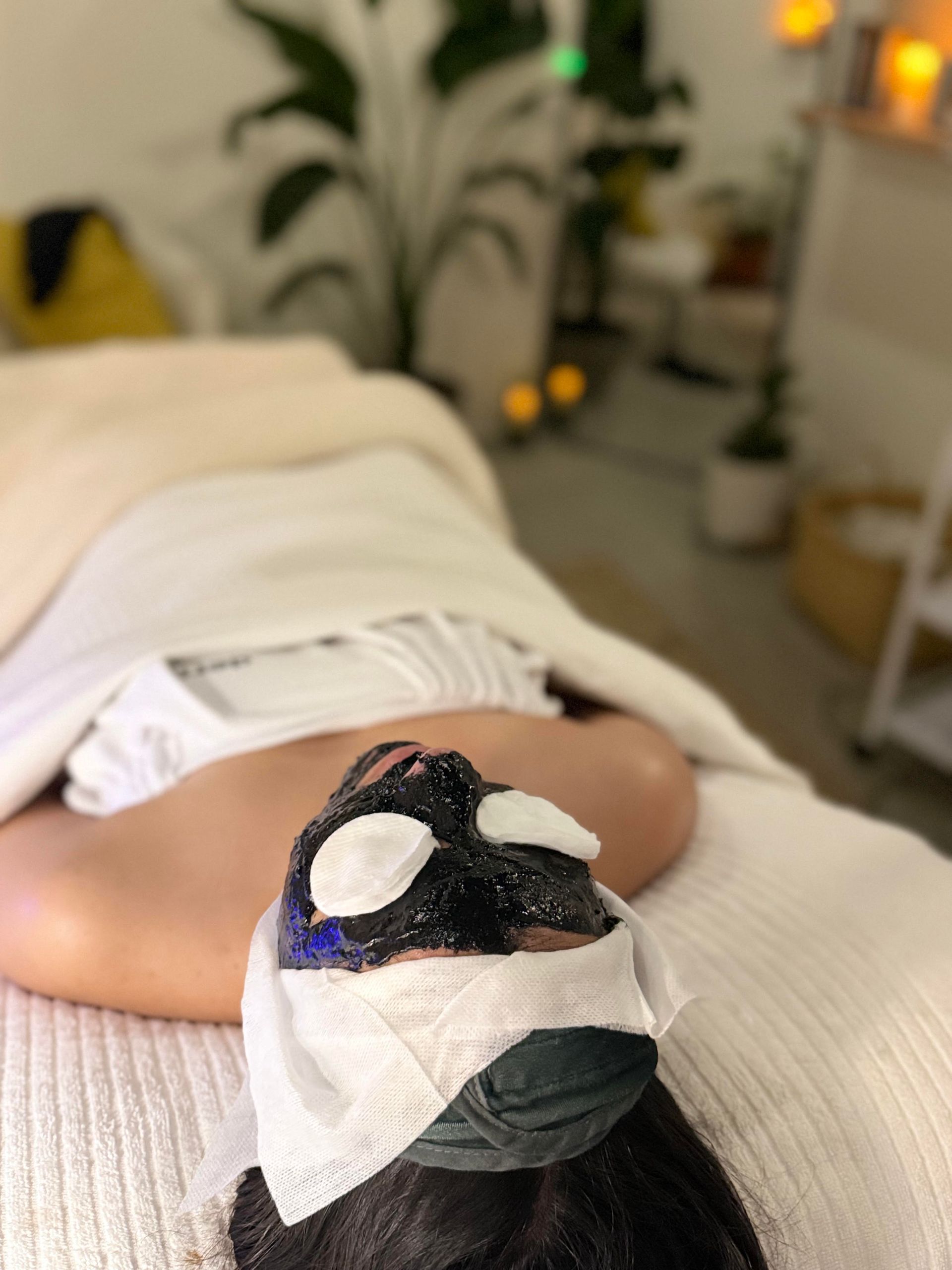 A woman is laying on a bed with a mask on her face.