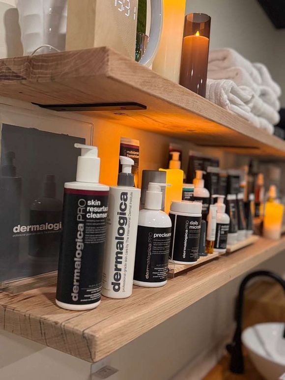 A shelf with candles and potted plants on it