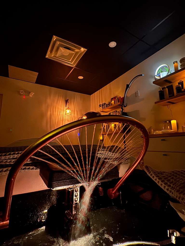 Spa room with copper wheel feature, lit with warm tones.