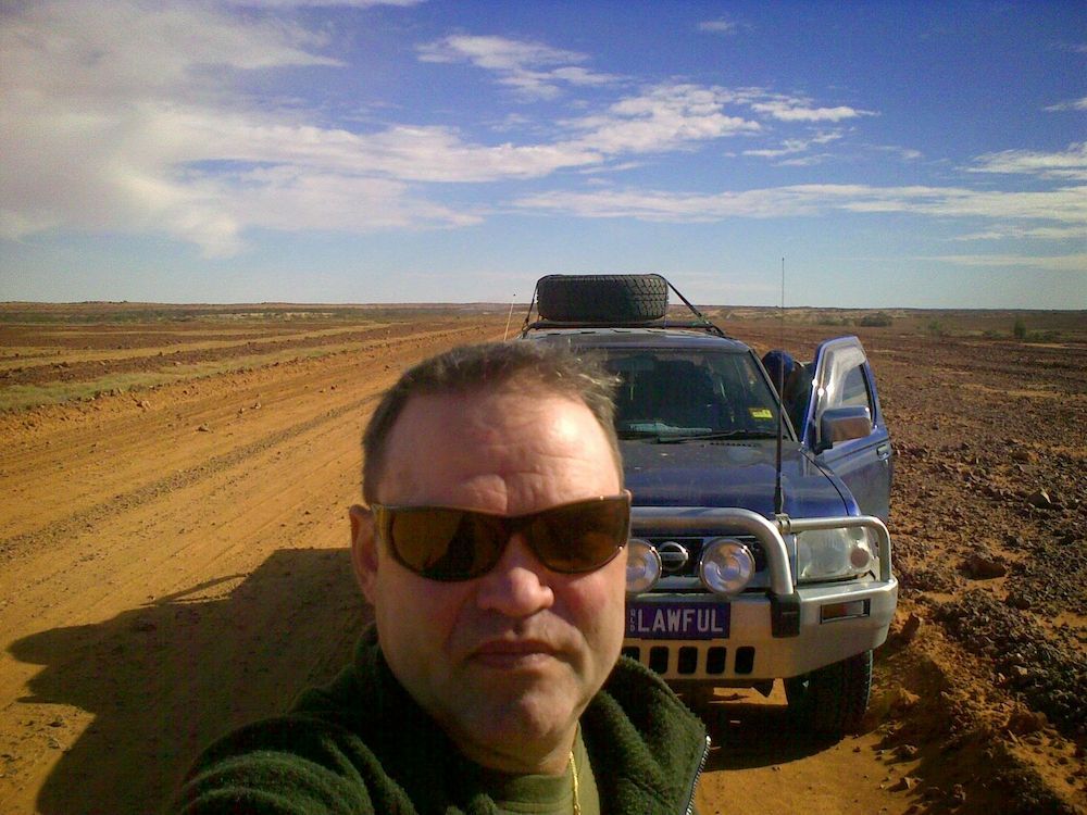 A Man in Front of a Car With a License Plate That Says Lawful — Cairns Criminal Lawyers In Cairns City, QLD