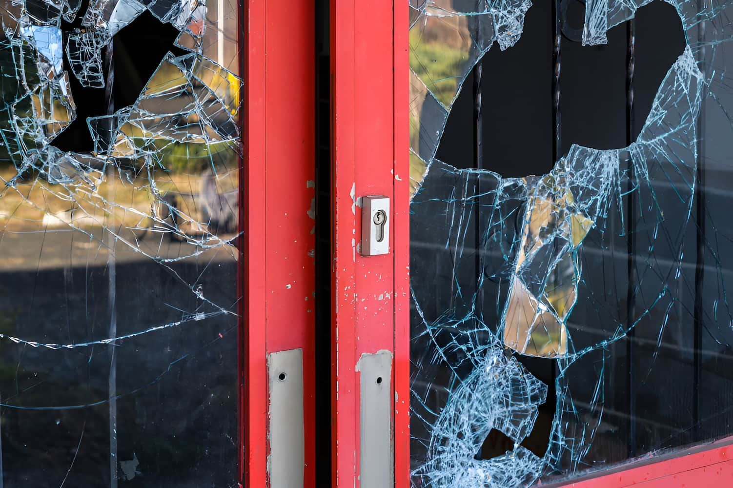 A Red Door With Broken Glass On It — Cairns Criminal Lawyers In Gordonvale, QLD