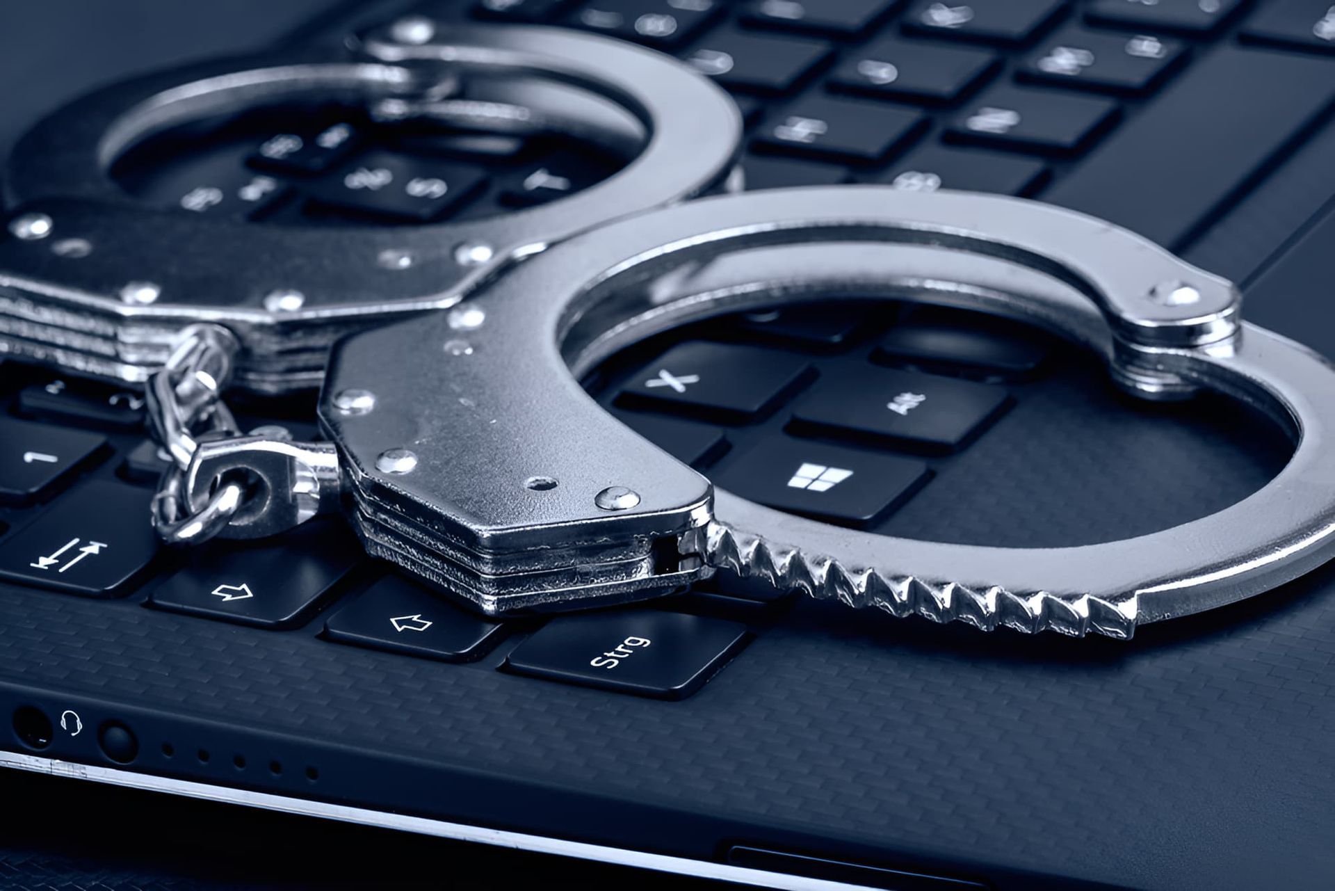 A Pair Of Handcuffs Laying On Top Of A Laptop Keyboard — Cairns Criminal Lawyers In Gordonvale, QLD
