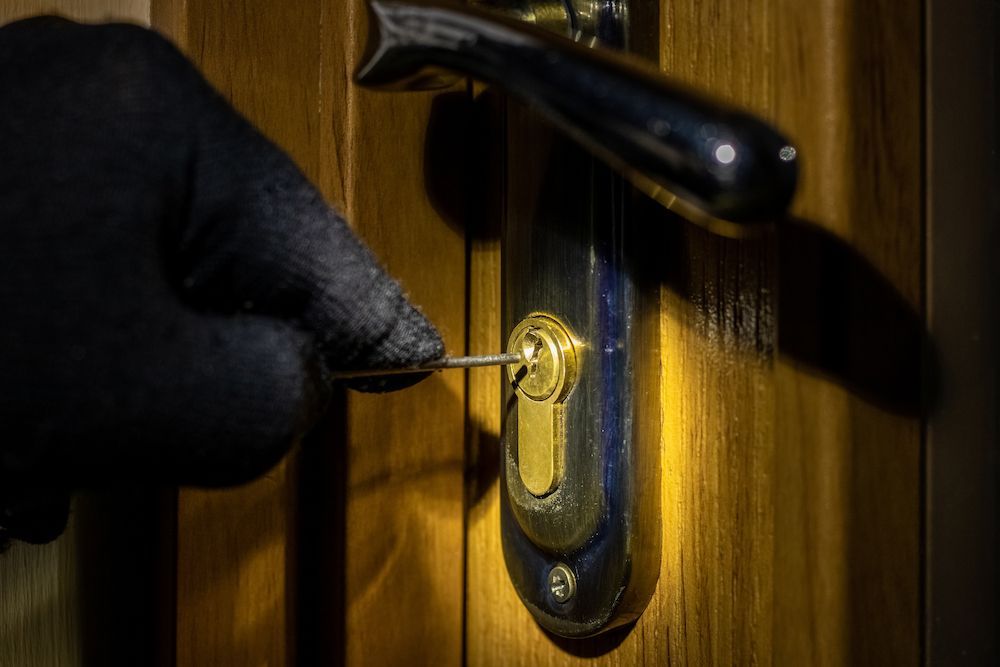 A Person is Holding a Key in a Door Lock — Cairns Criminal Lawyers In Cairns City, QLD