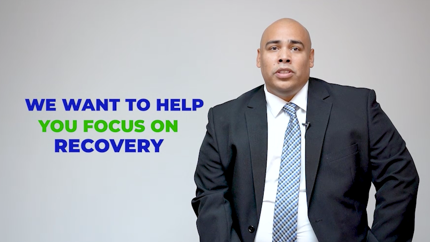 A man in a suit and tie is standing in front of a sign that says we want to help you focus on recovery