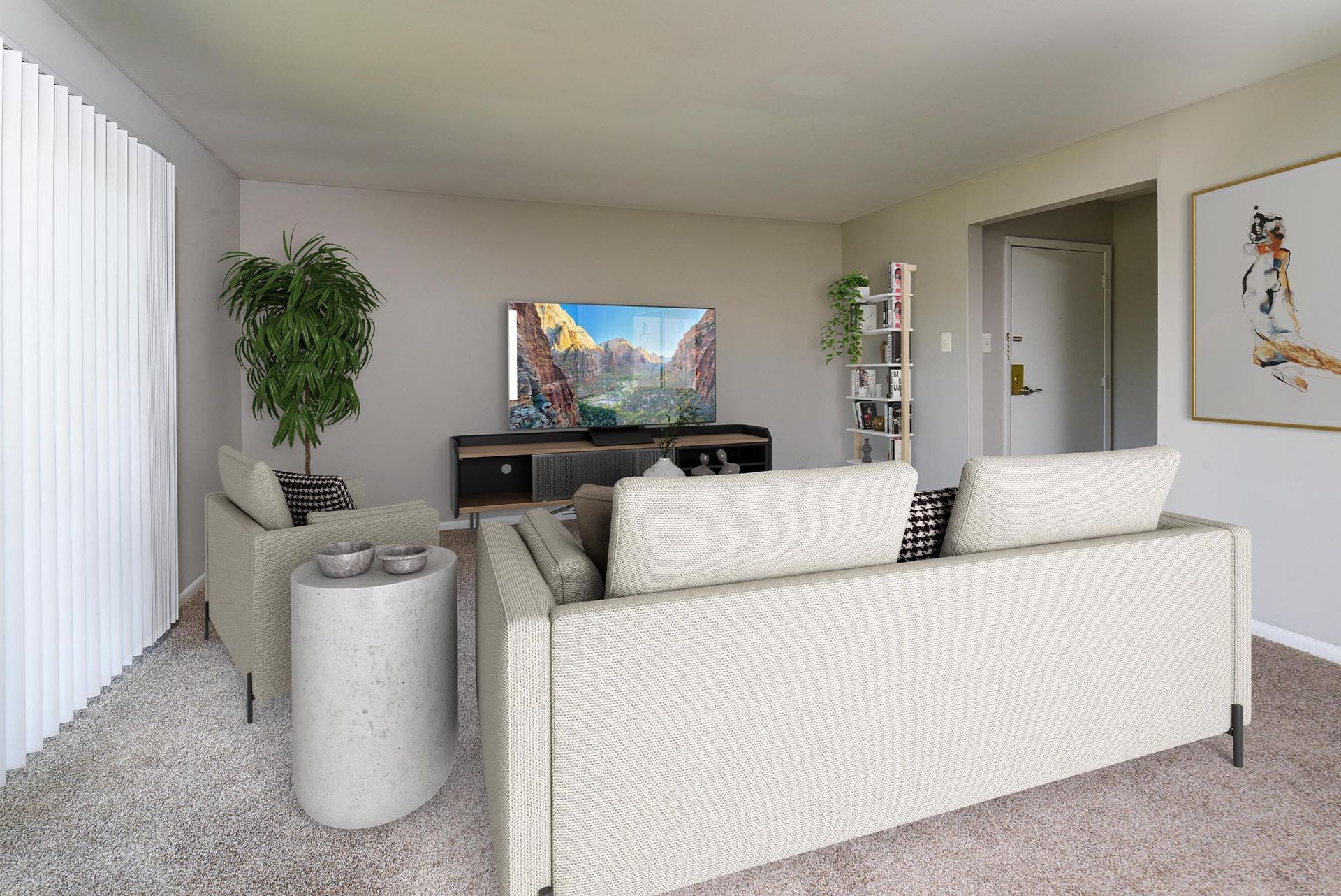 Living room in an apartment with a beige sofa, TV on a media console, a tall plant, and a white bookshelf.