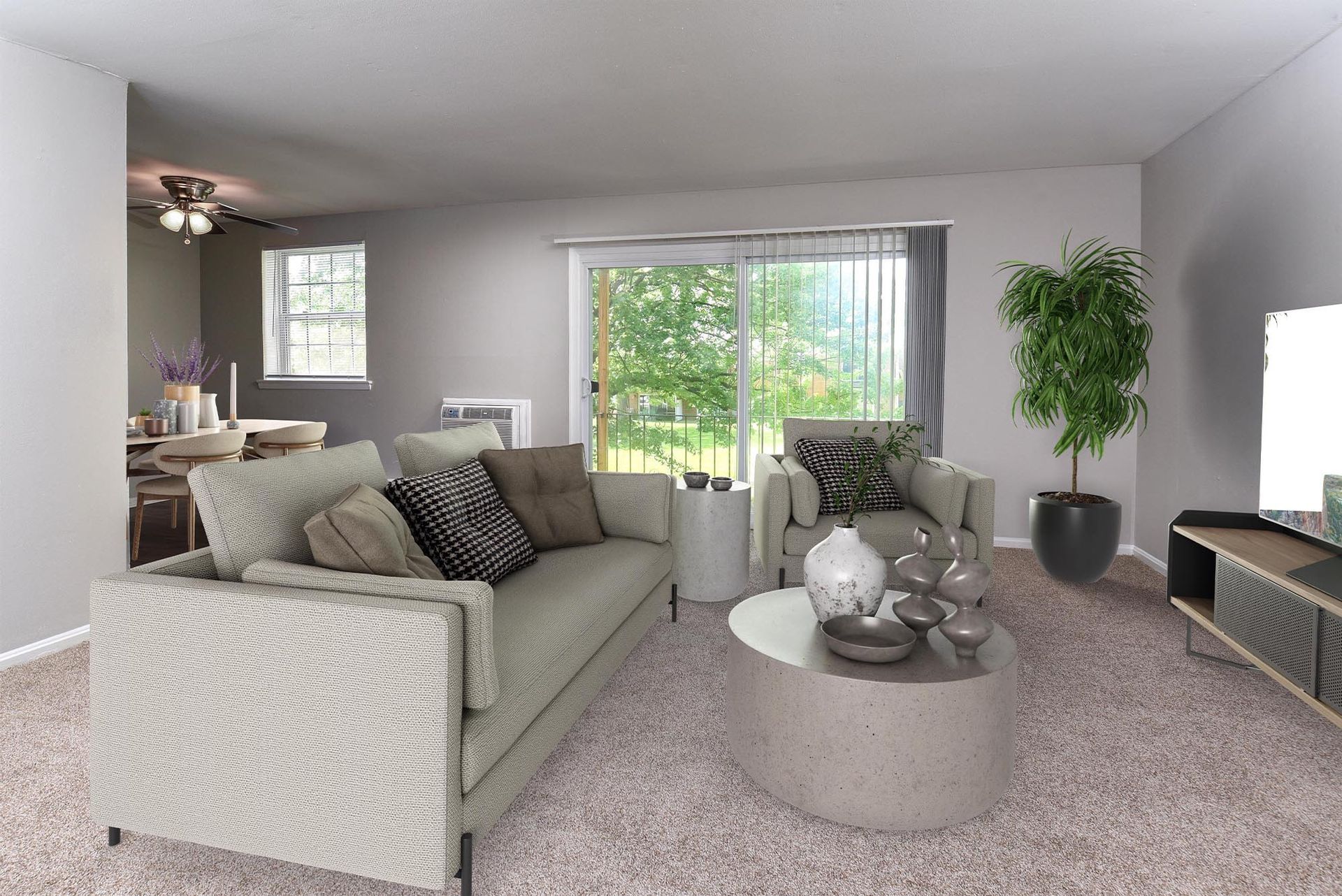 Living room with two beige sofas, a round concrete coffee table, and a sliding glass door to a balcony.