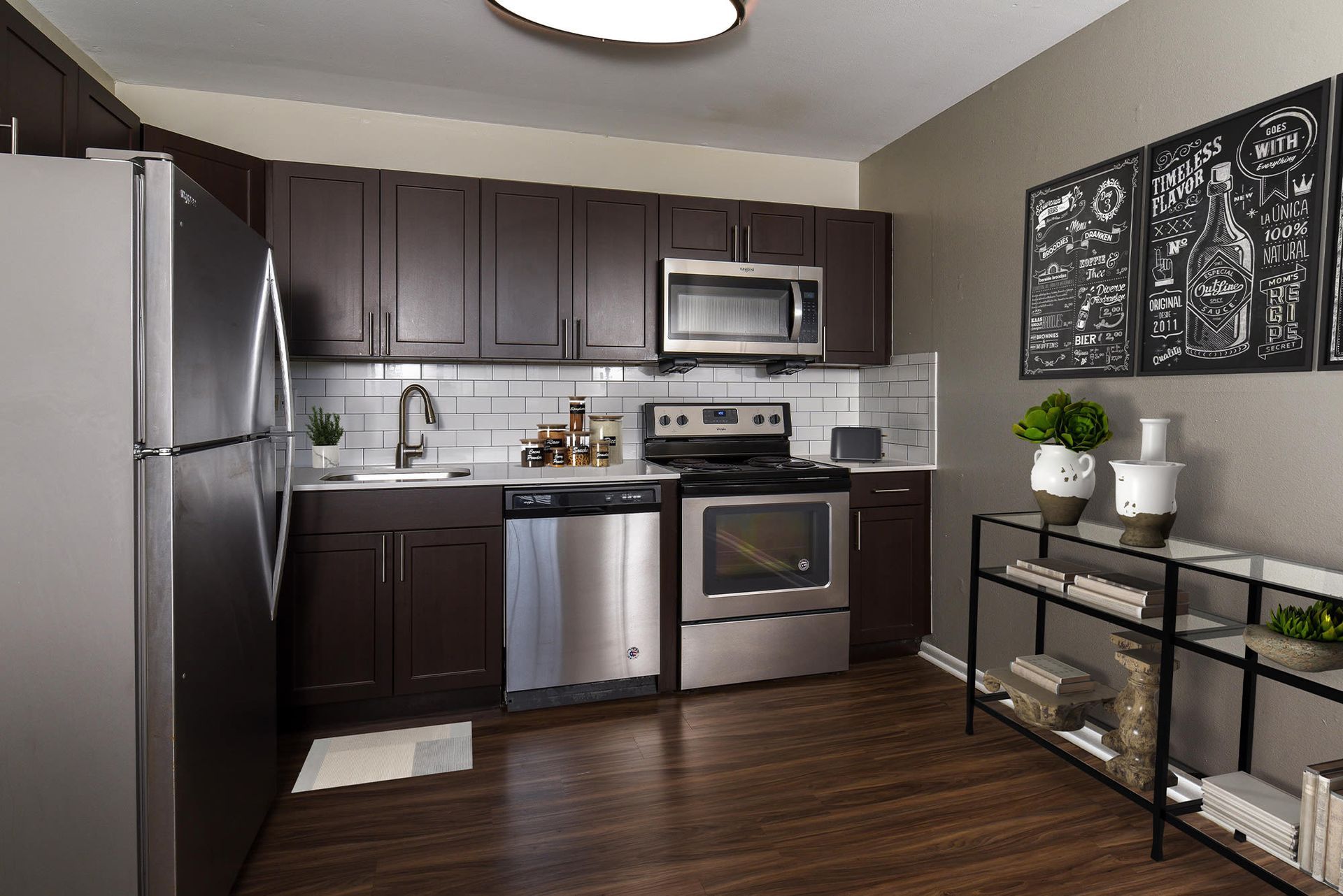 Kitchen with dark wood cabinets, stainless steel appliances, and a white subway tile backsplash.