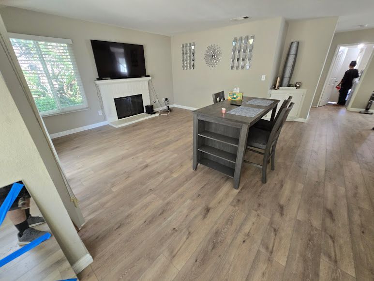 Bright open dining room with fireplace, wall-mounted TV, wood floors, and a table in the center