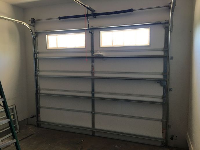 Garage door with two windows, inside a garage.