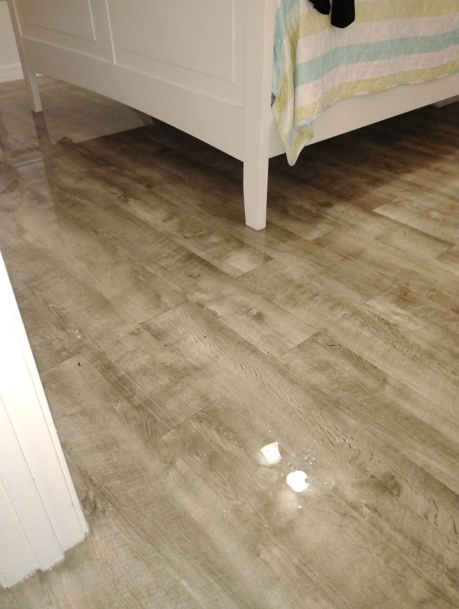 A bedroom with a bed and a wooden floor.