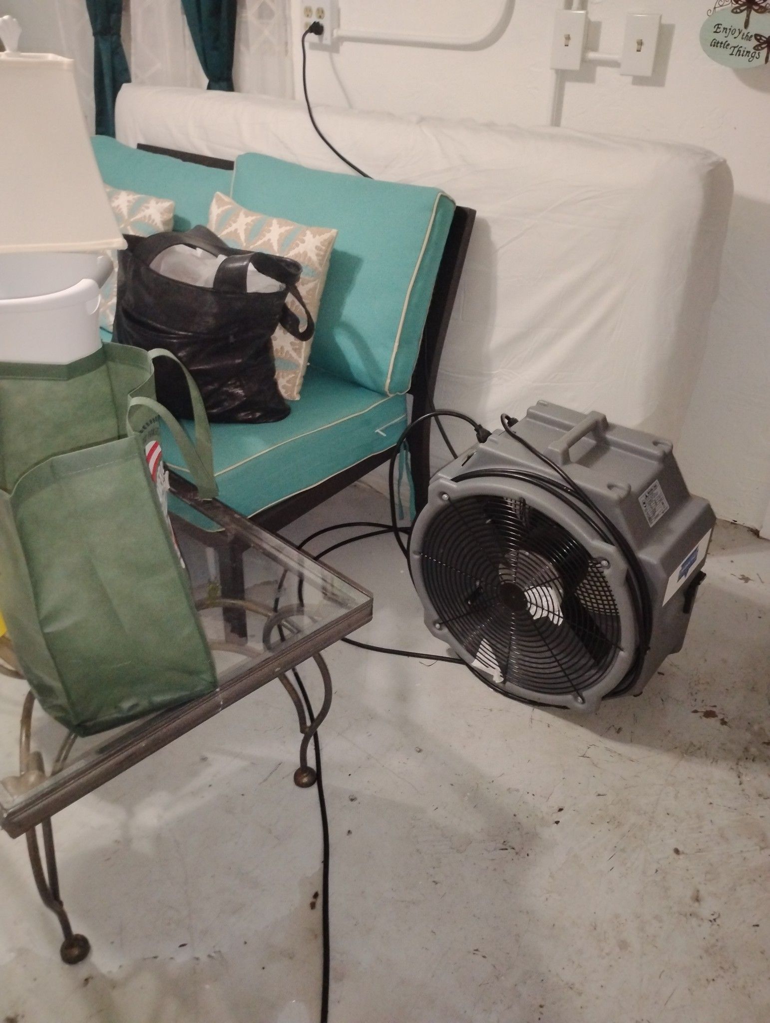 A fan is sitting next to a chair in a room.