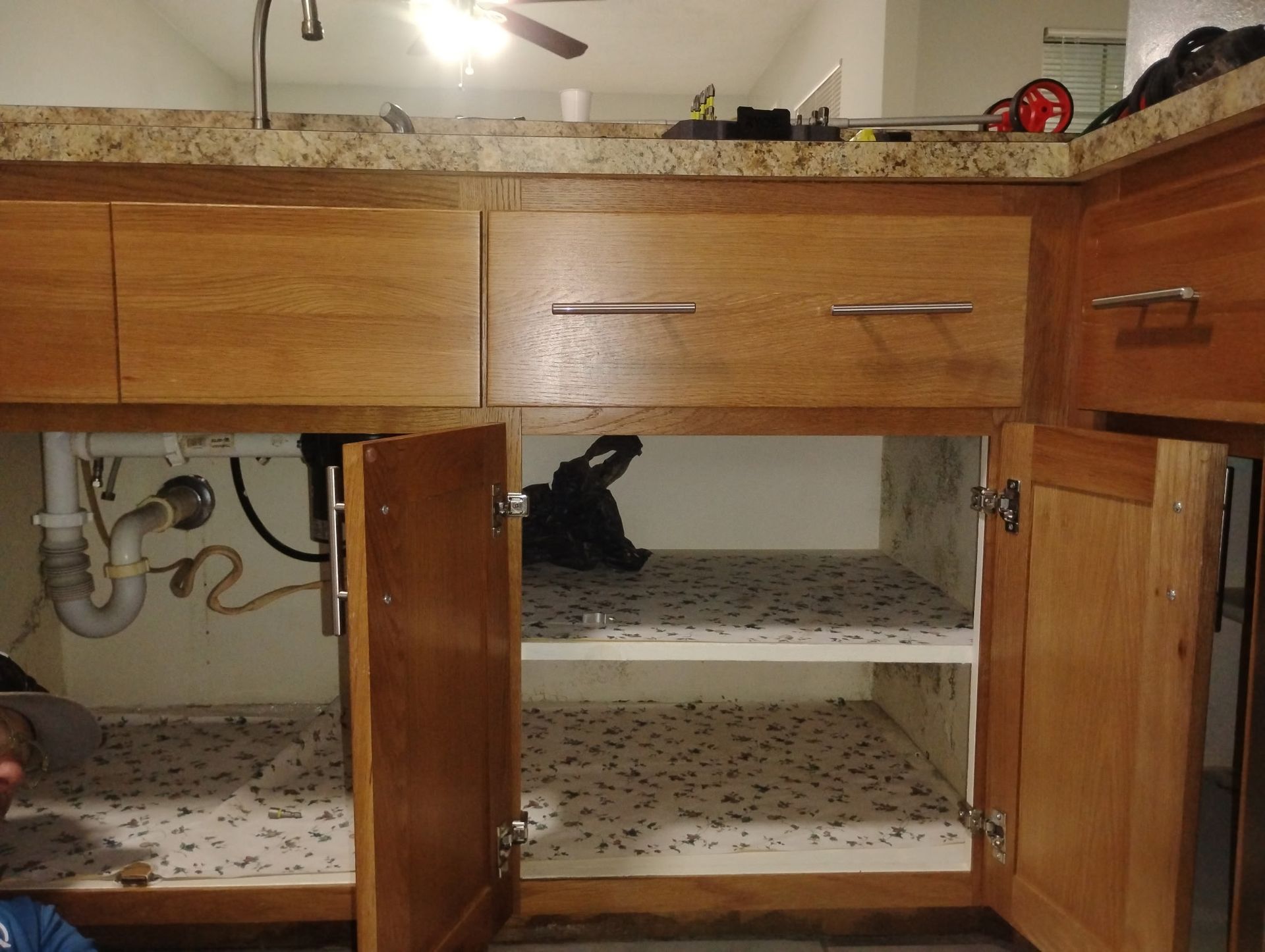 A bathroom vanity with the doors open and a sink underneath it