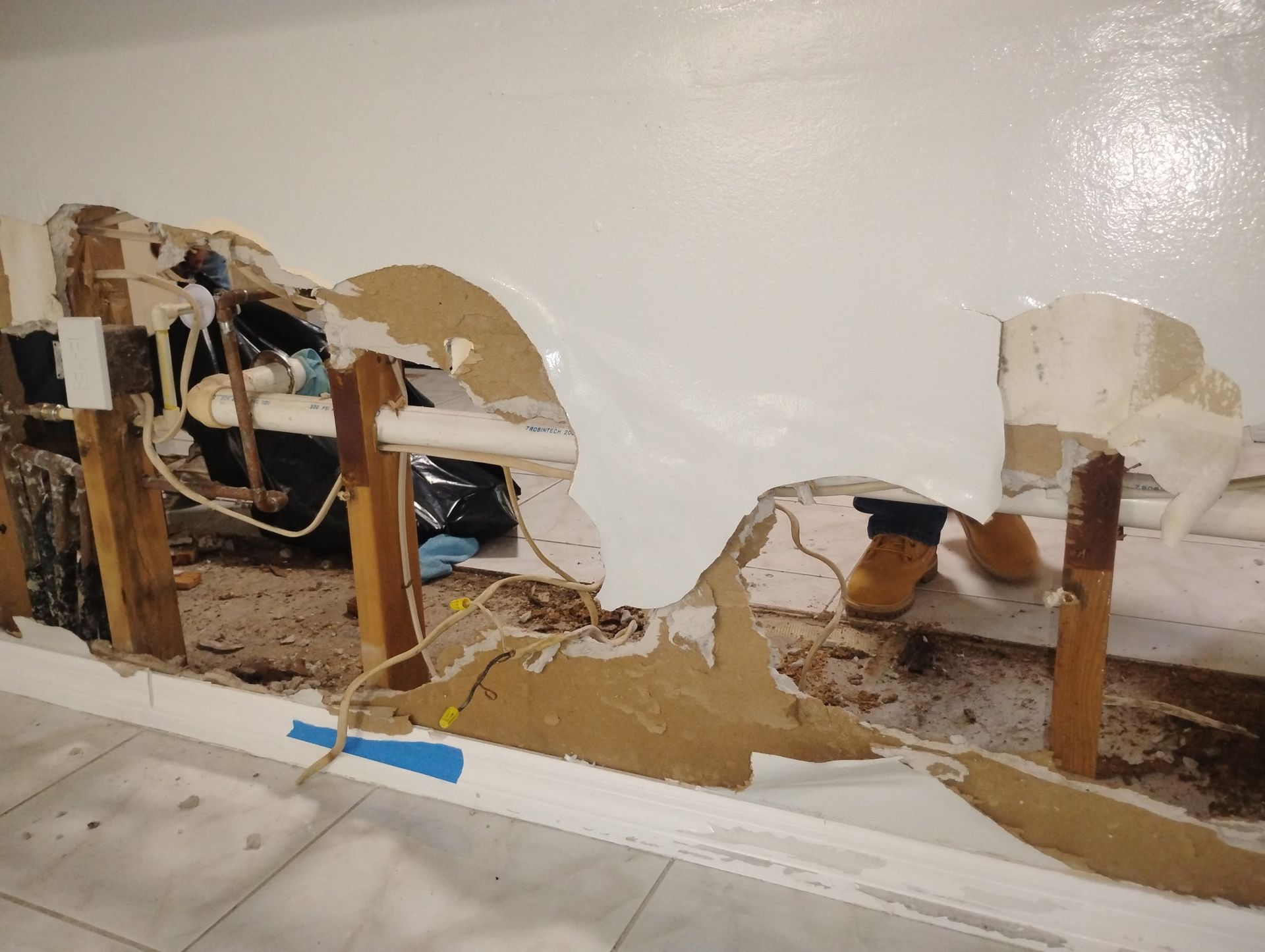 A wall with a hole in it is being repaired.