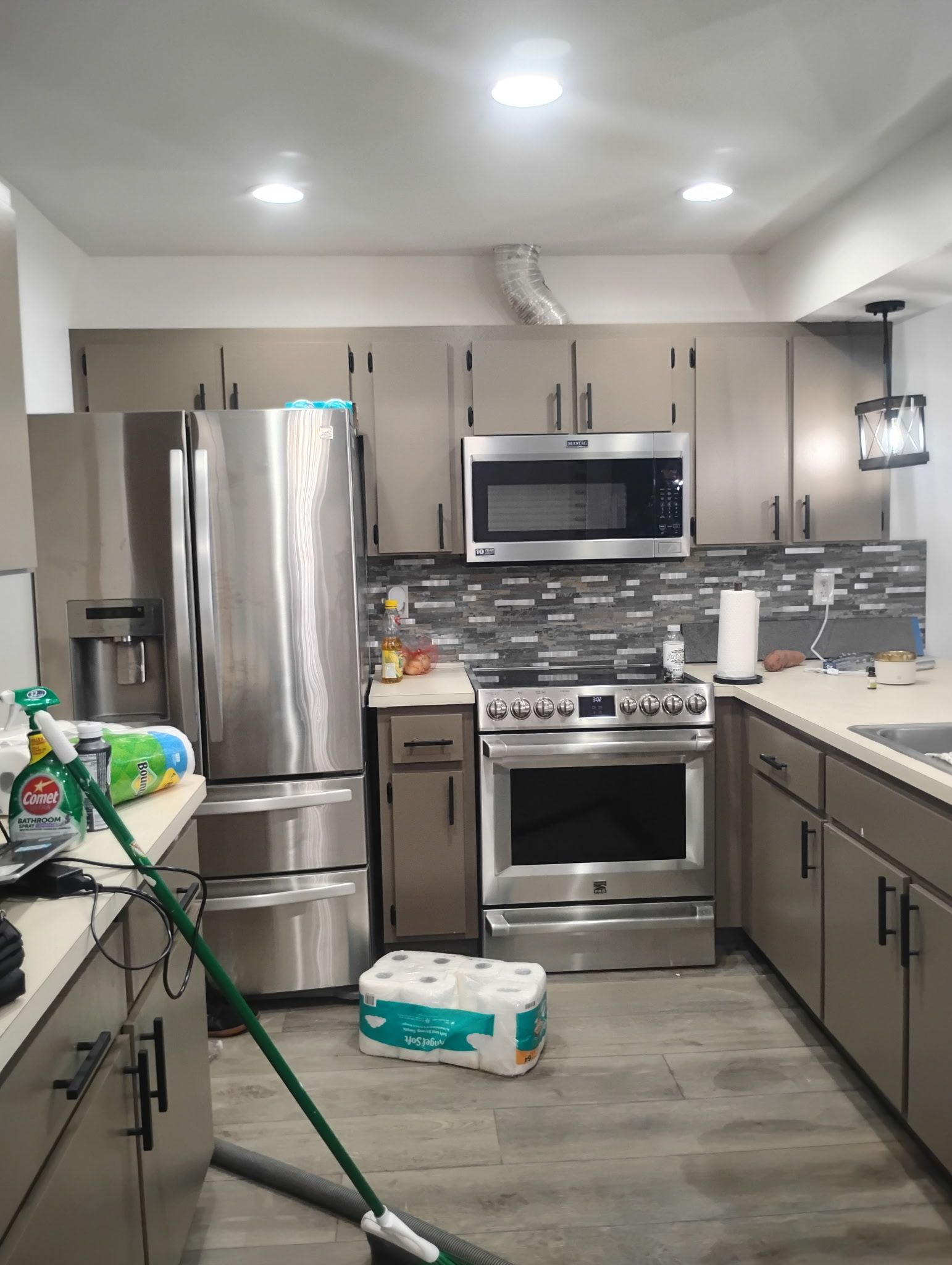 Kitchen with stainless steel appliances, neutral cabinets, and a tiled backsplash.