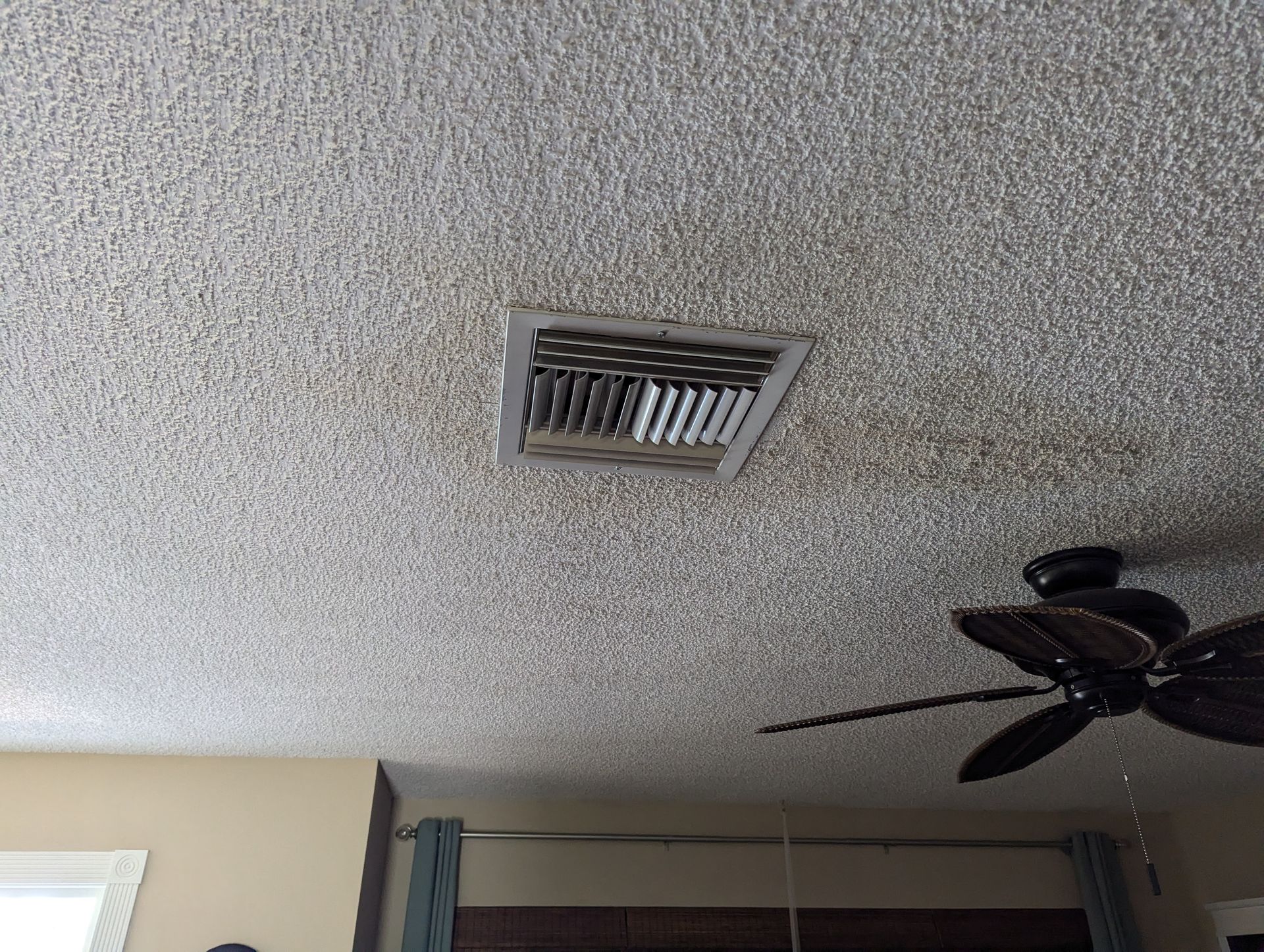 A ceiling fan is hanging from the ceiling of a living room.