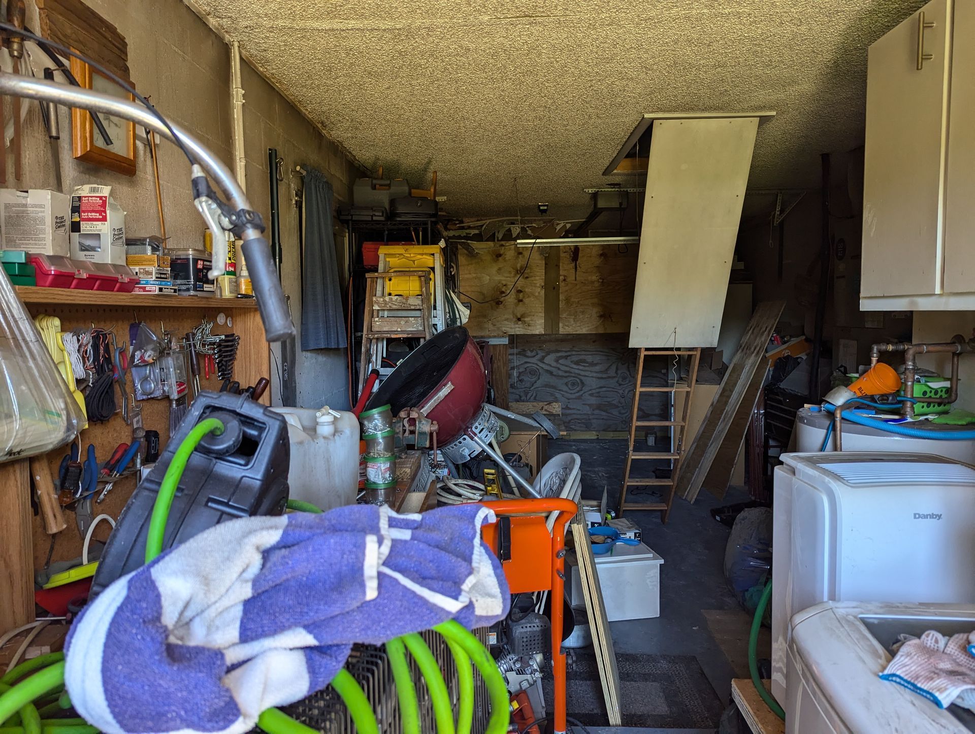 A messy garage with a purple towel on the floor