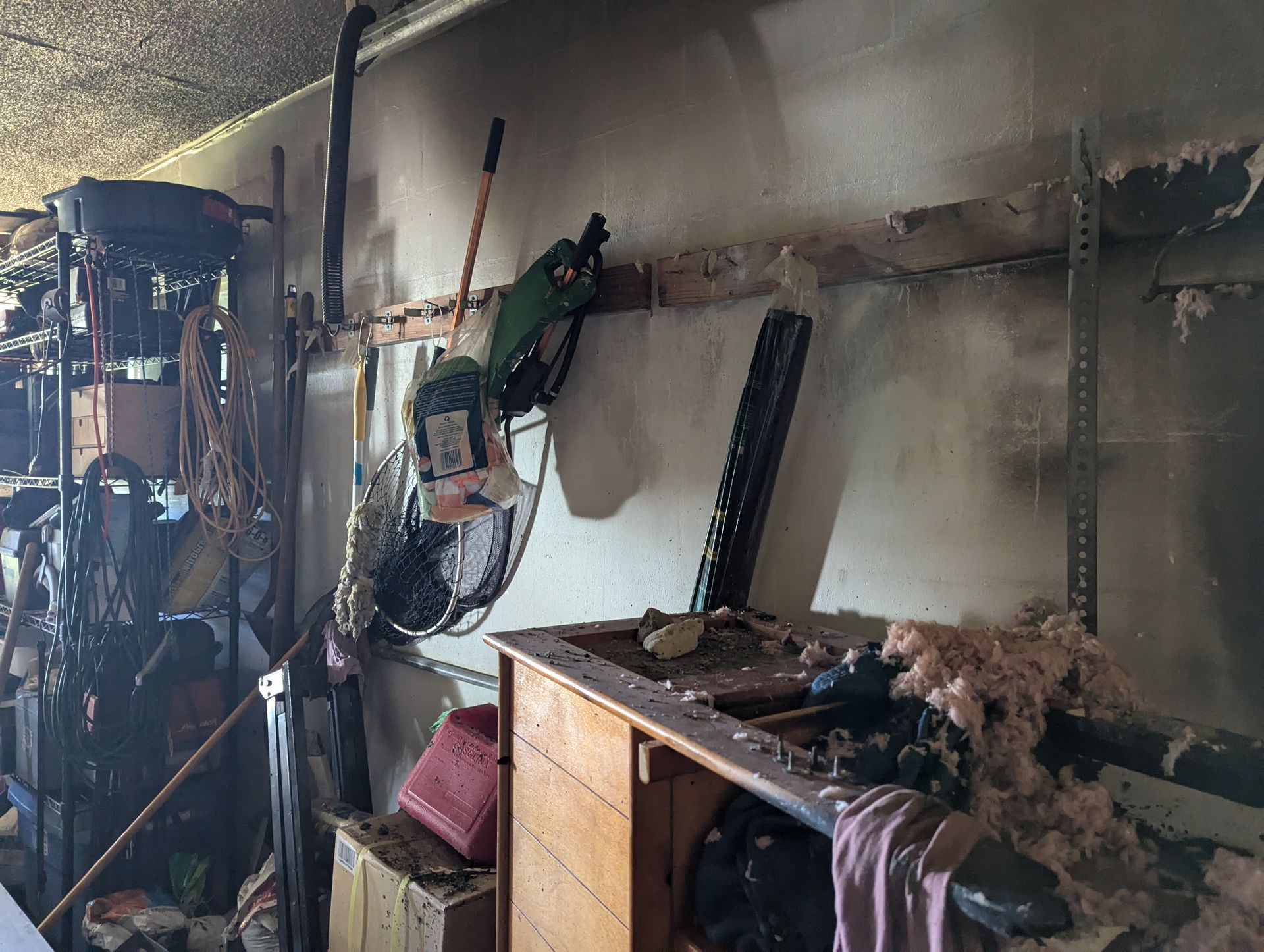 A messy room with a lot of tools on the wall.