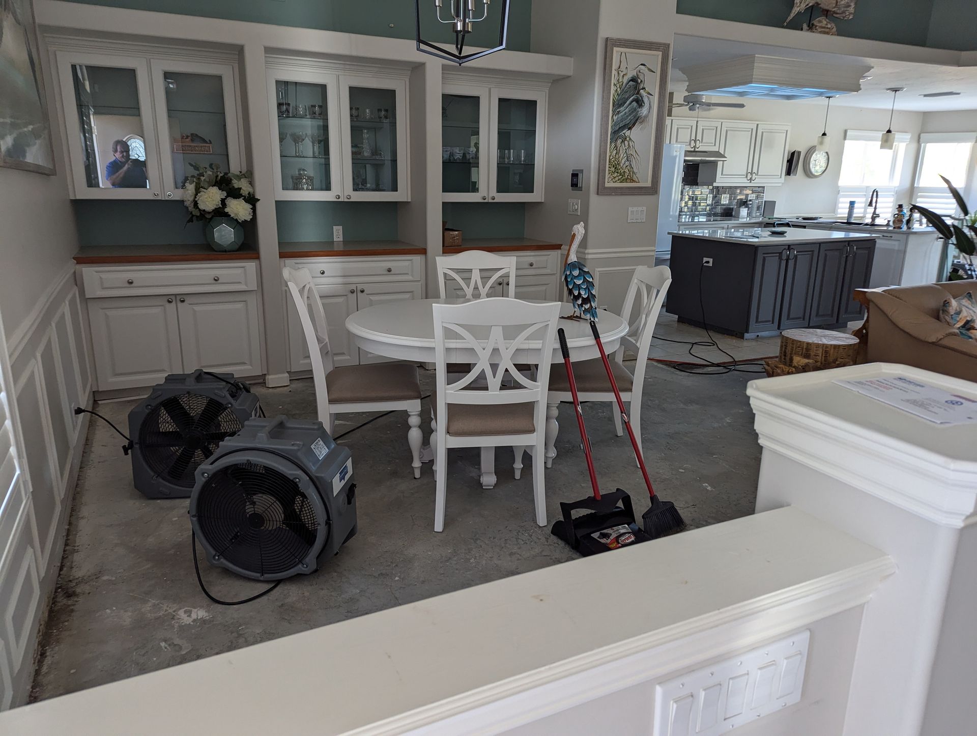 A dining room with a table and chairs and a fan.