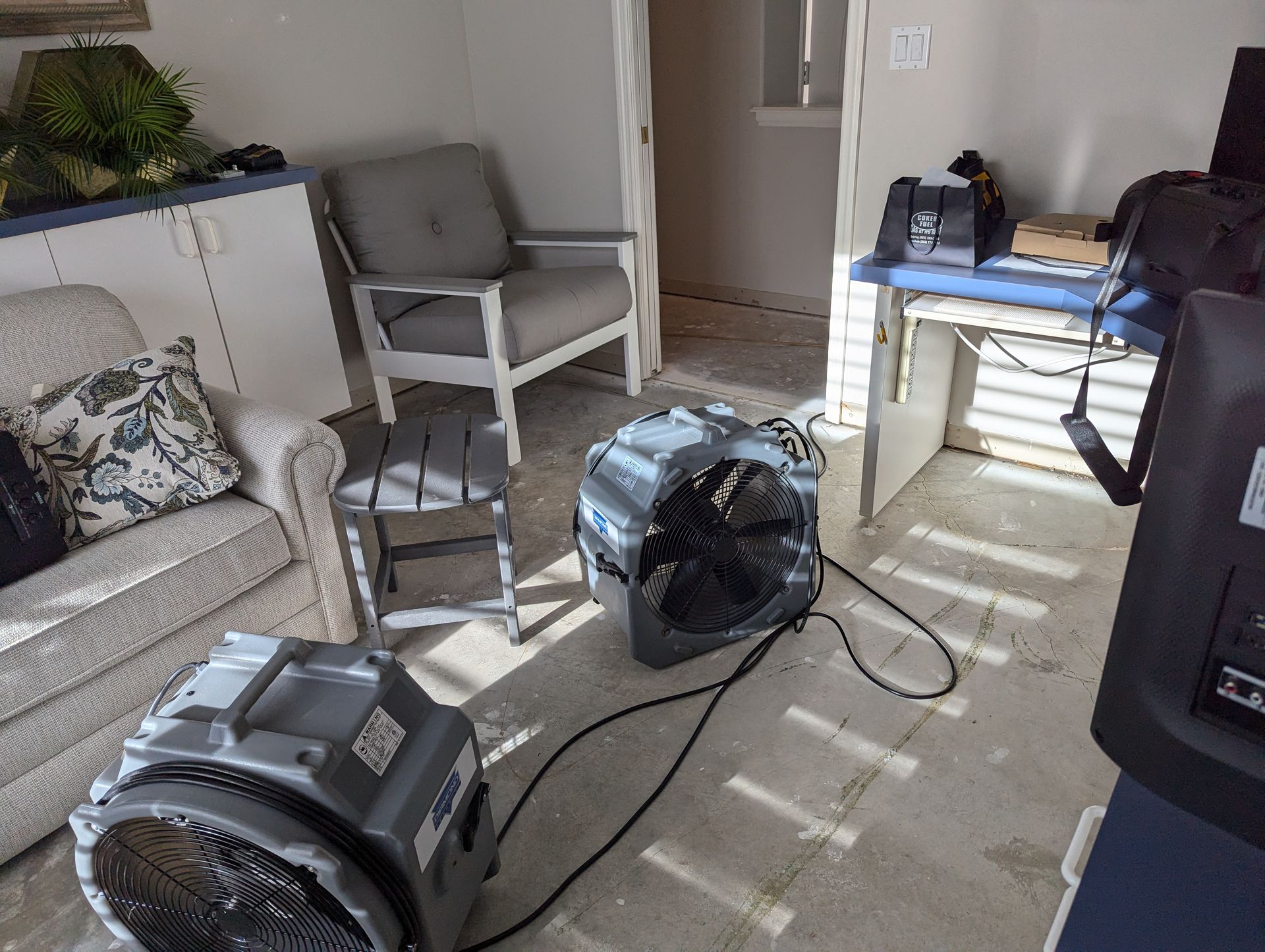 Two fans are sitting on the floor in a living room.