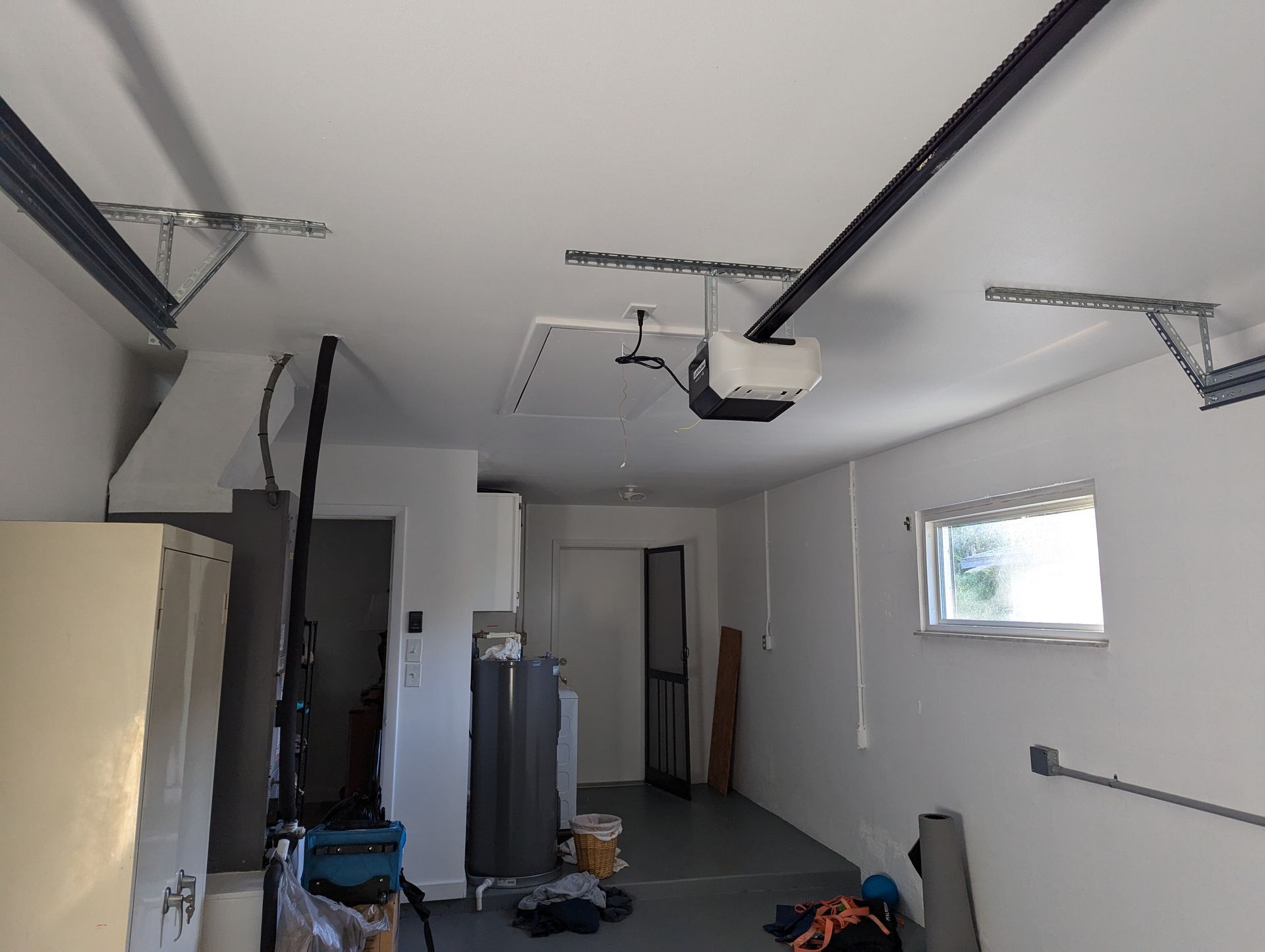 A garage with a garage door opener hanging from the ceiling