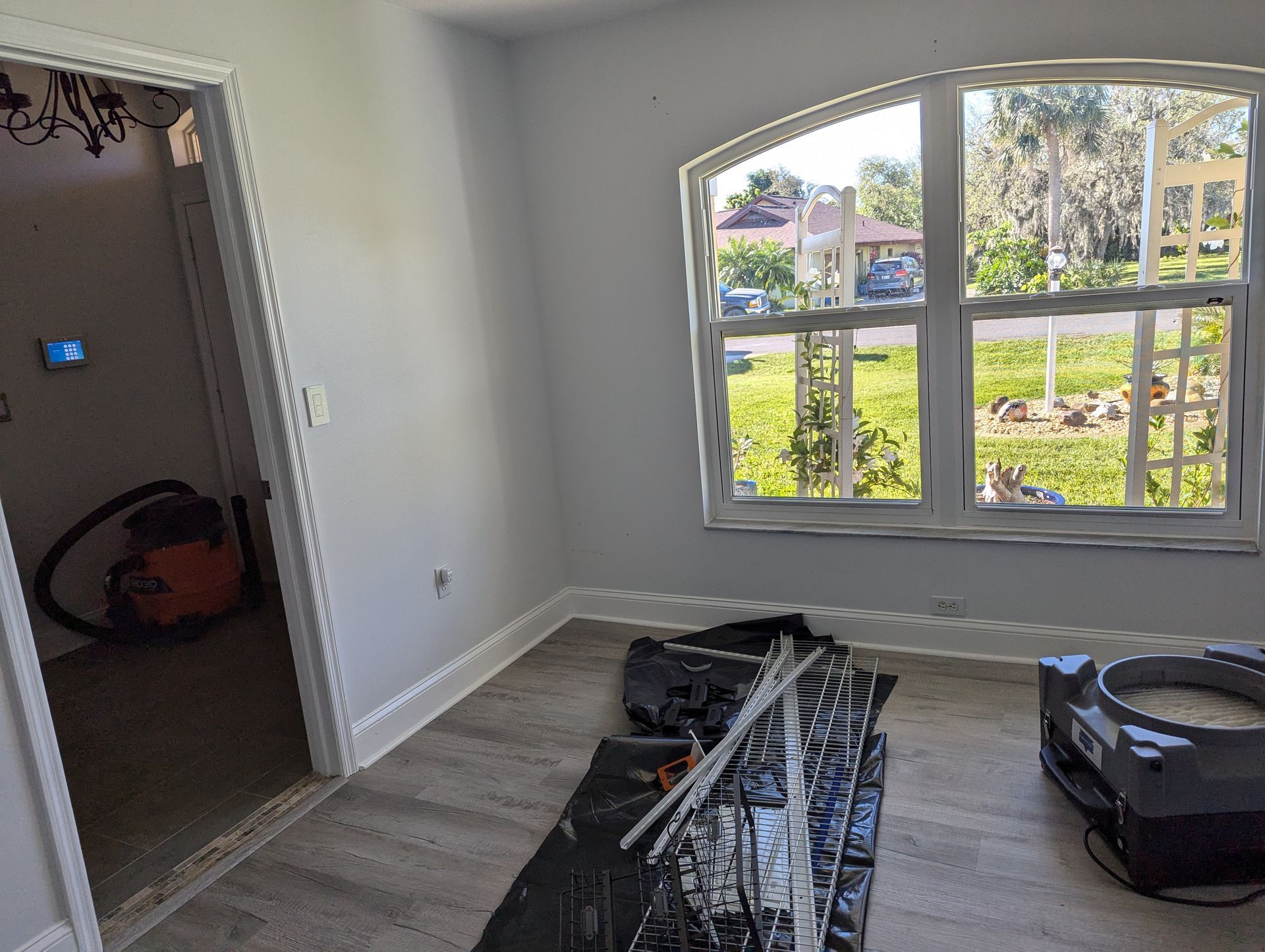 A room with a lot of windows and a vacuum cleaner on the floor.
