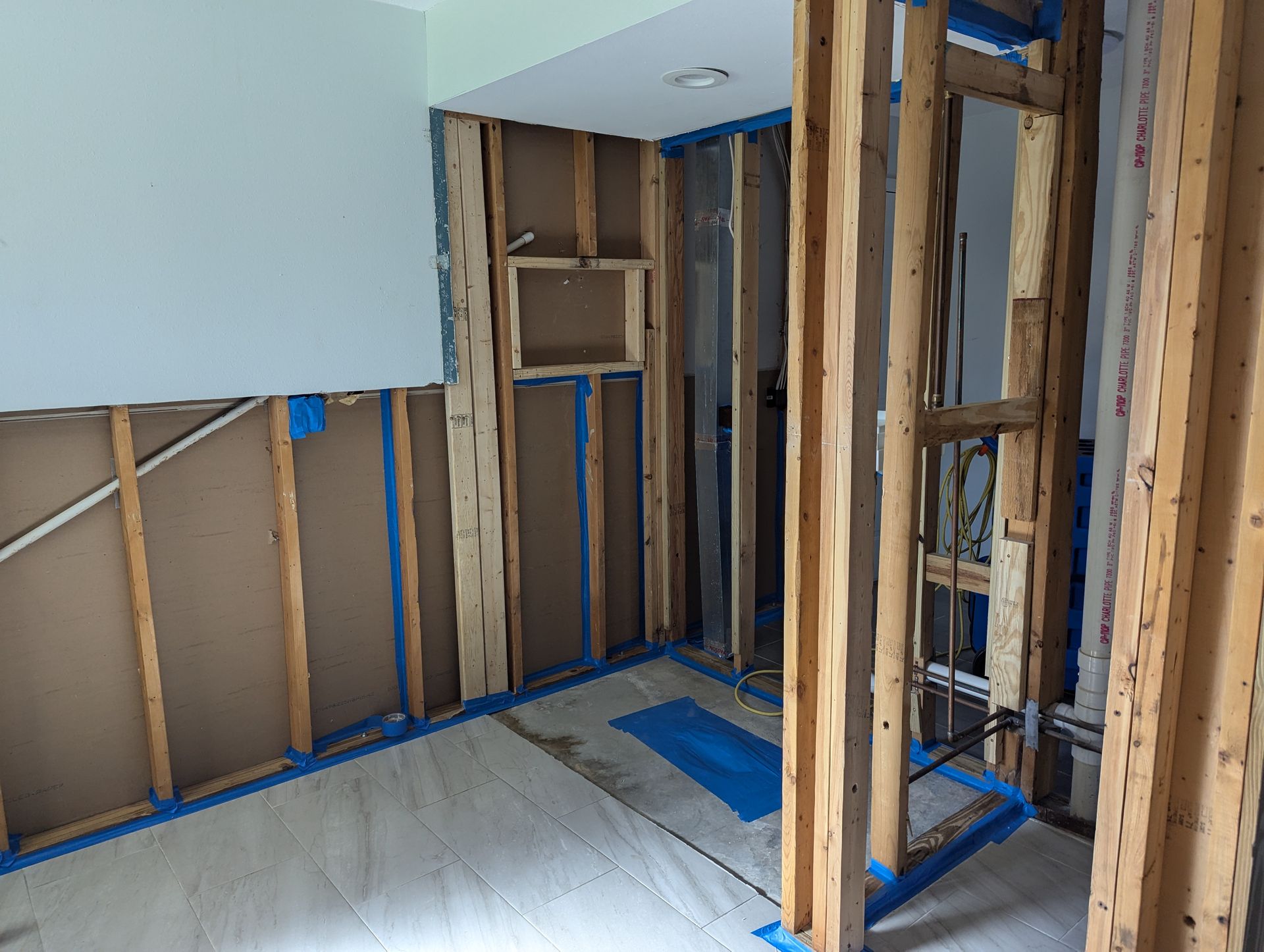 A room with wooden beams and blue tape on the floor.