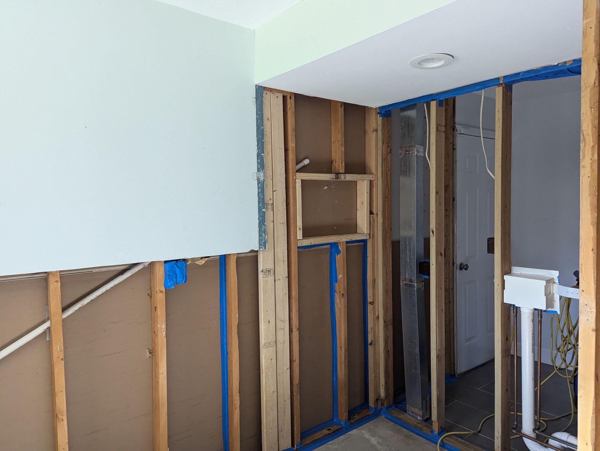 A room with wooden walls and a blue tape on the wall.