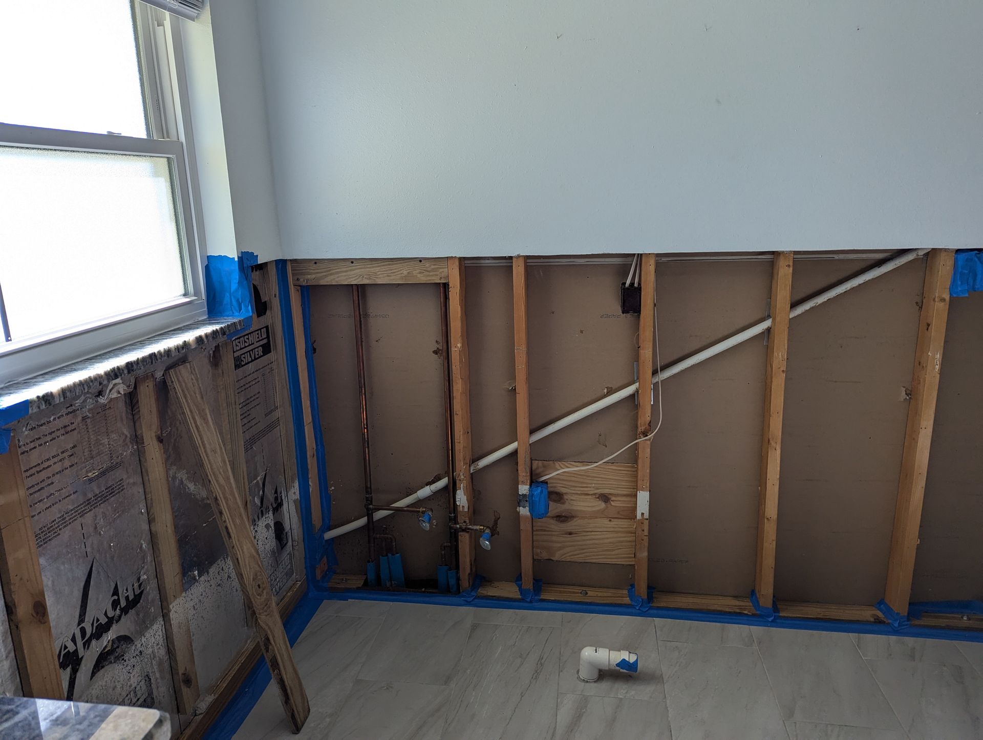 A room with a wooden wall and a window.