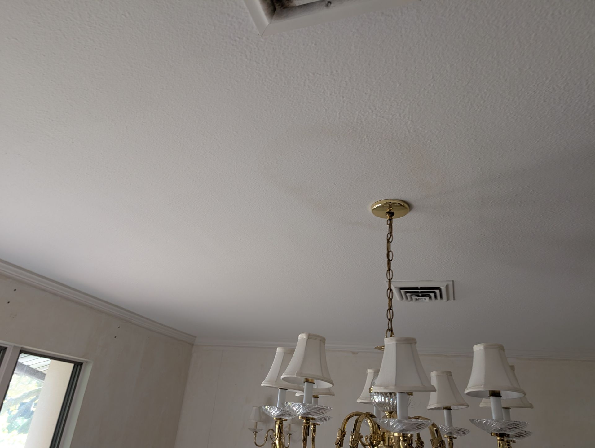 White ceiling with water stain and chandelier.