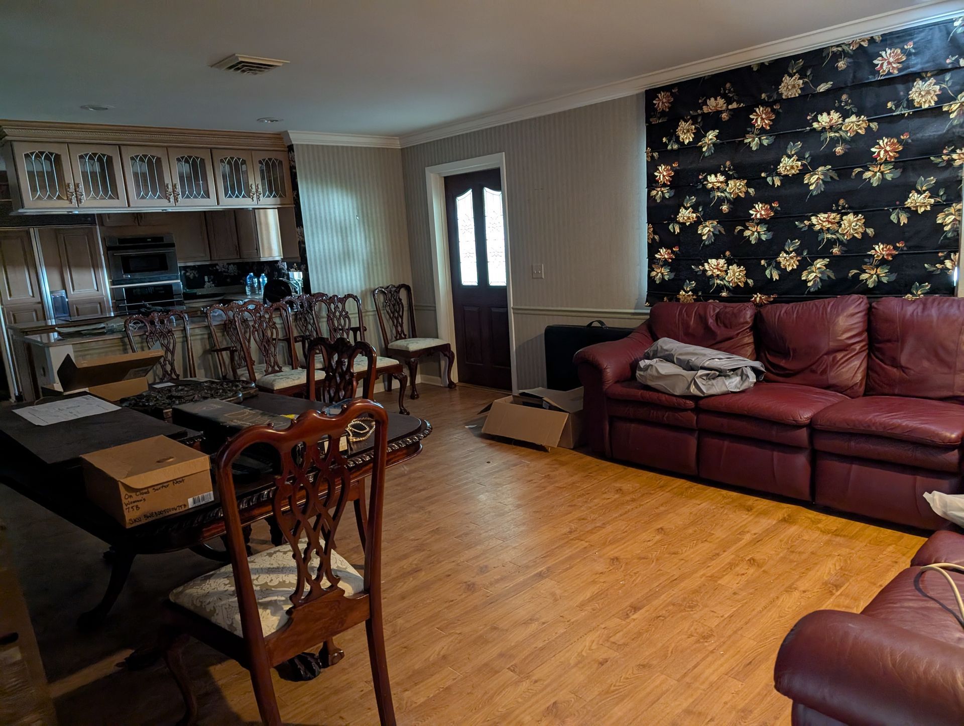 Interior shot of a living/dining room combo with a sofa, table, chairs, and a kitchen.