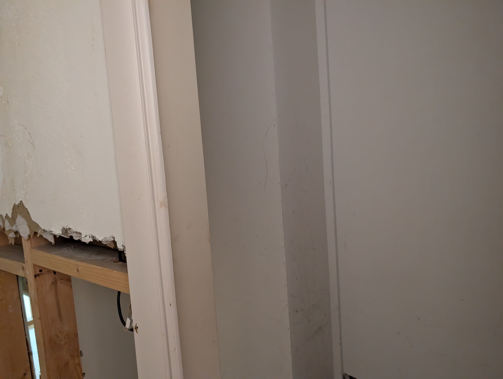 Interior view with unfinished wall, trim, and partially exposed wooden framing.