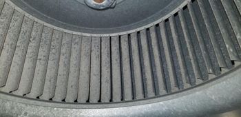 A close up of a dirty air conditioner blower.