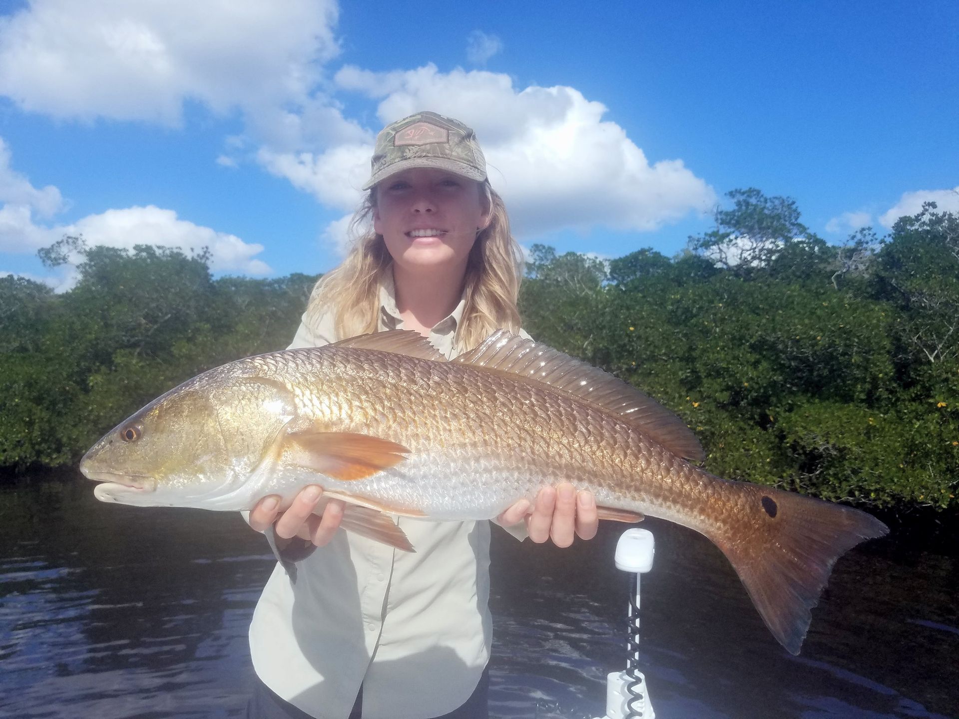 A woman is holding a large fish in her hands