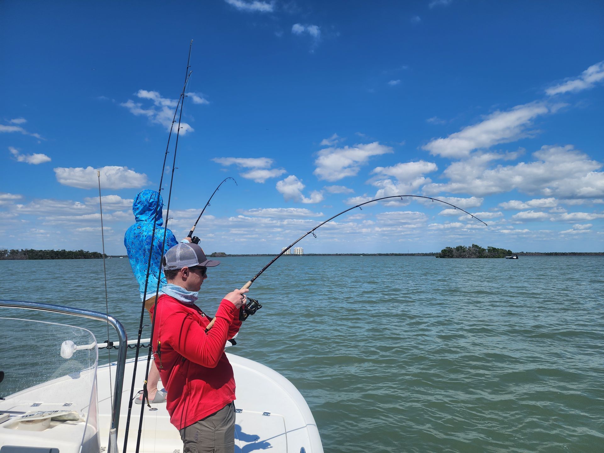 A man is fishing on a boat in the ocean.