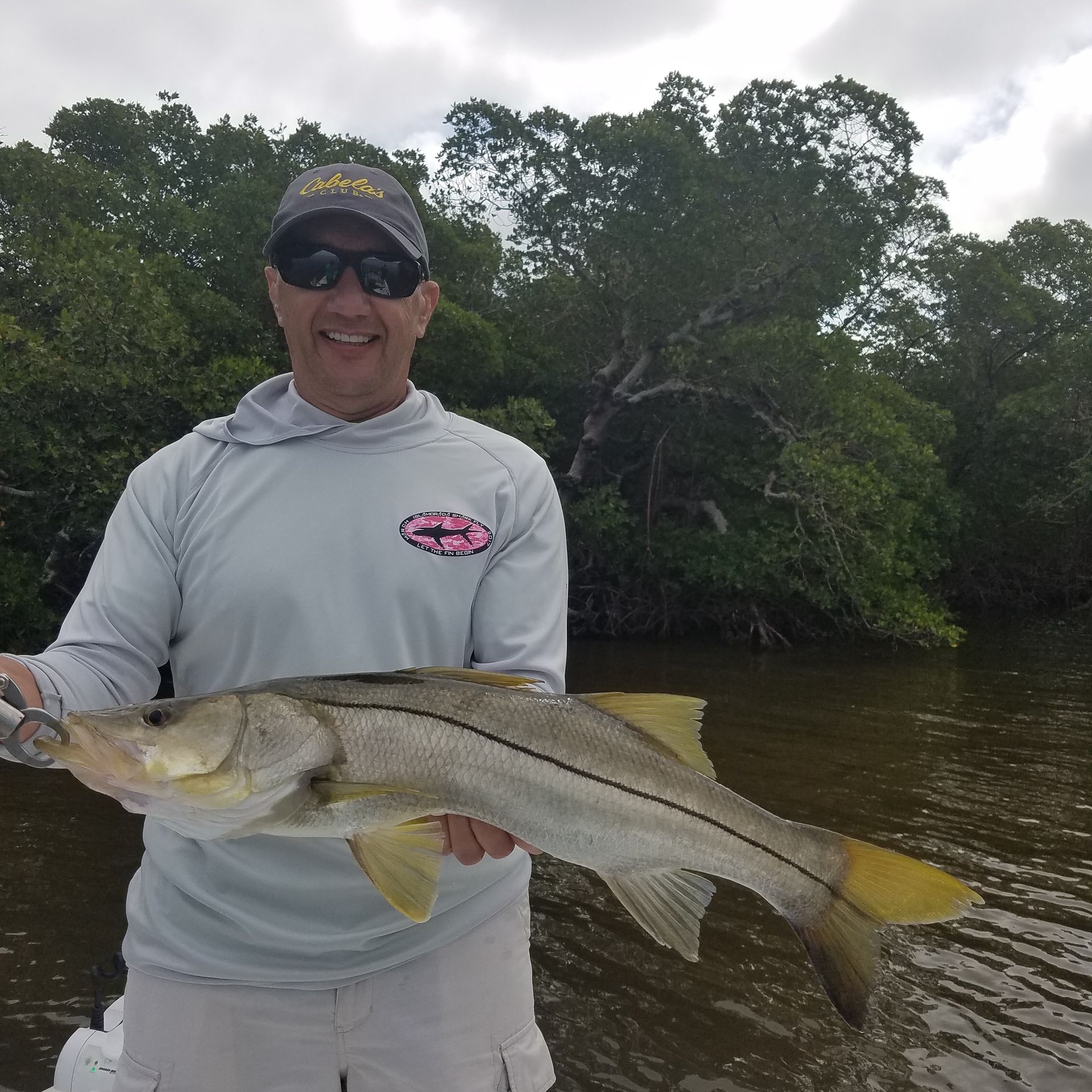 A man is holding a large fish in his hands