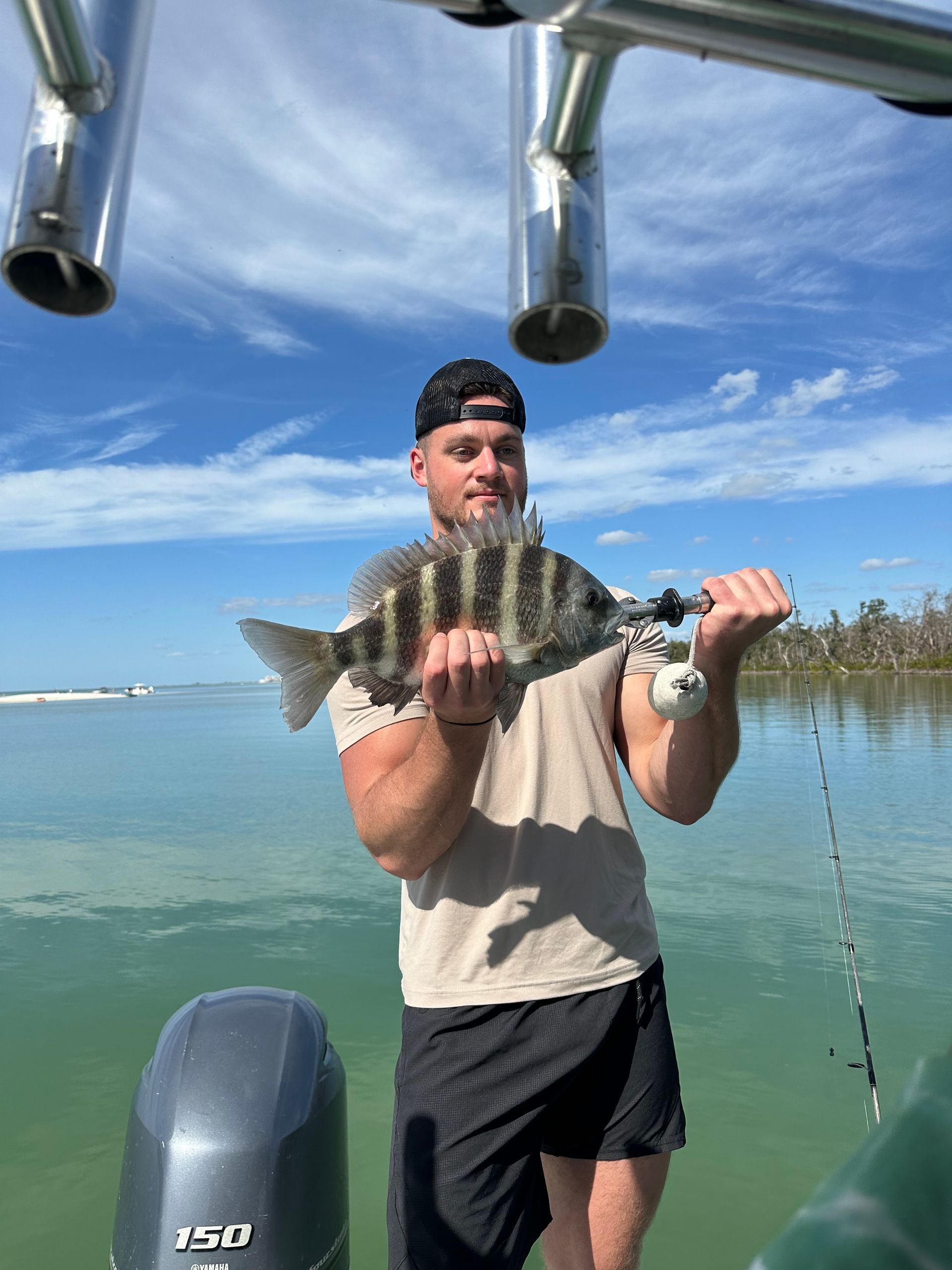 A man is standing on a boat holding a fish in his hands.