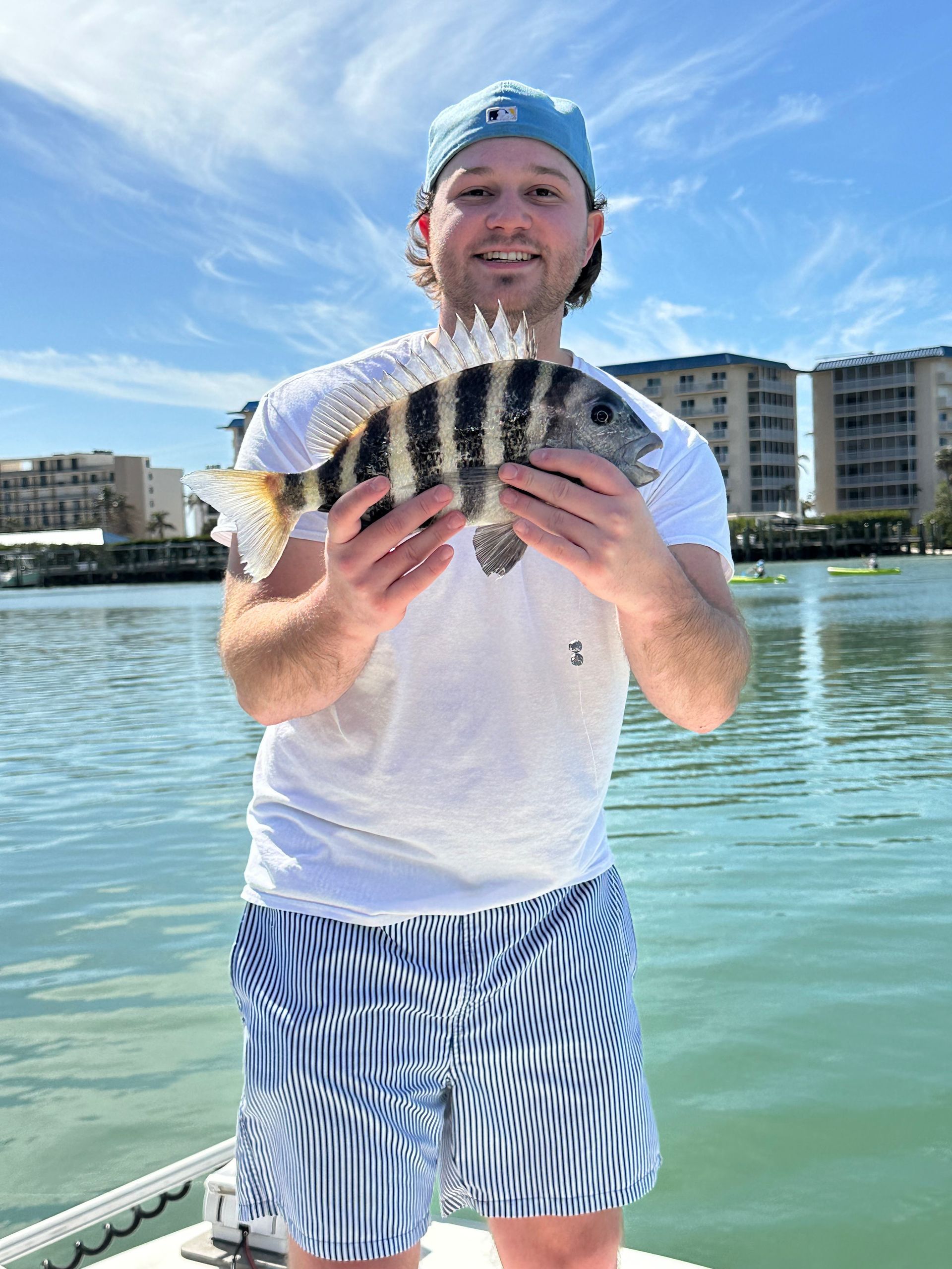 A man is holding a fish in his hands on a boat.