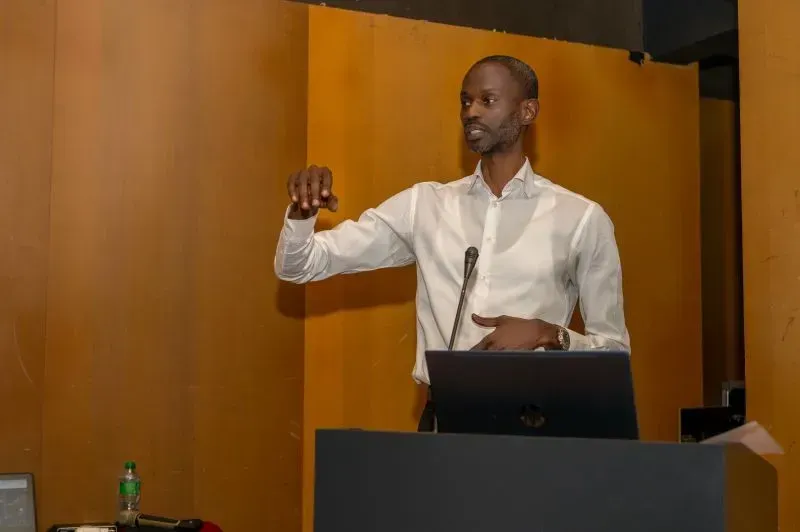 Un homme se tient debout sur un podium et fait une présentation.