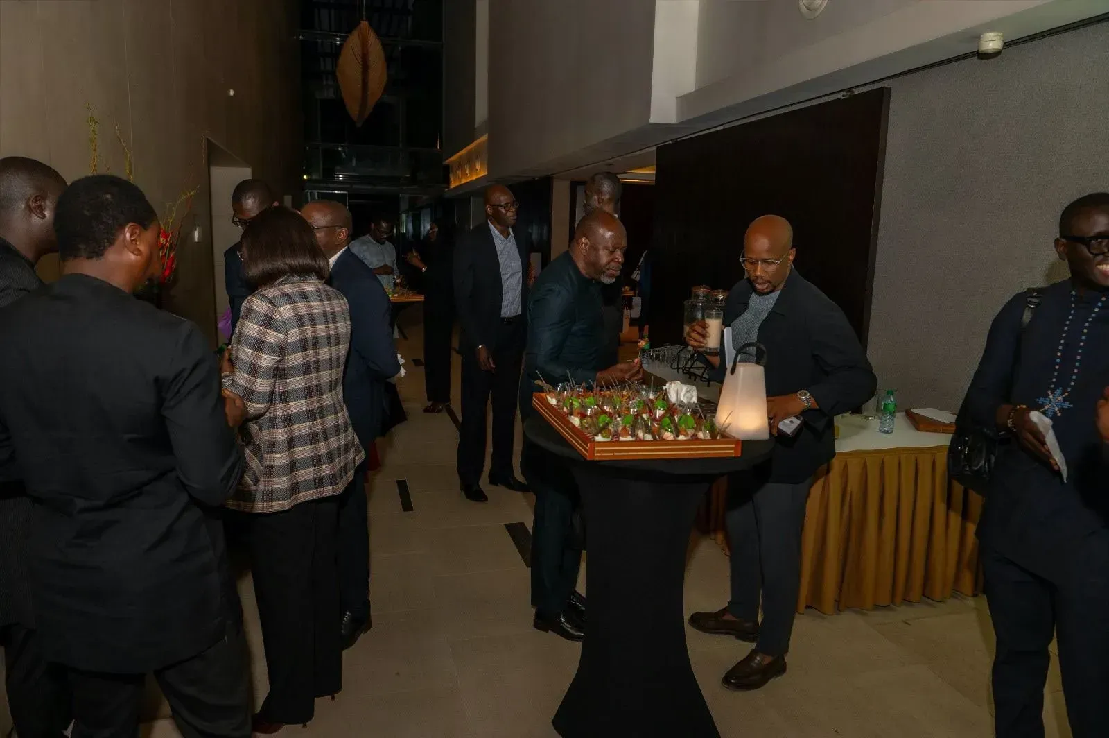 Un groupe de personnes se tient autour d'une table avec de la nourriture dessus.