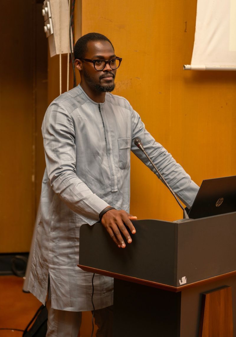 Un homme se tient debout sur un podium avec un ordinateur portable dessus.