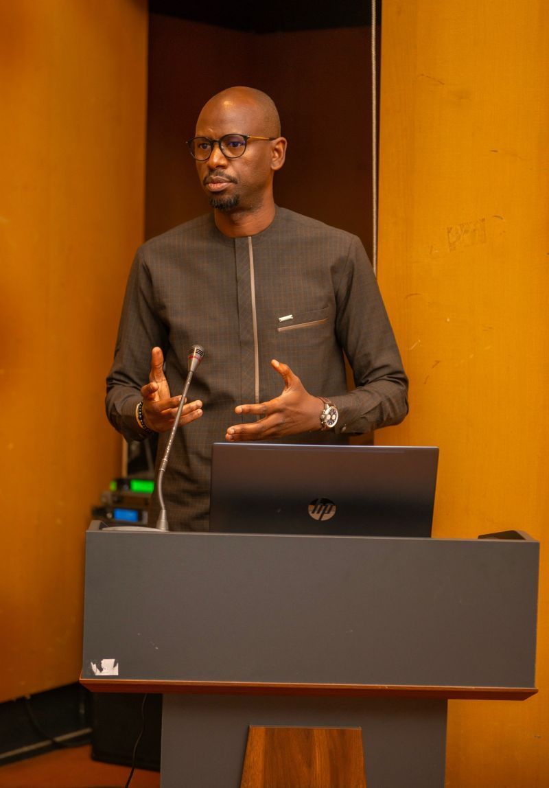 Un homme se tient debout sur un podium avec un ordinateur portable et un microphone.