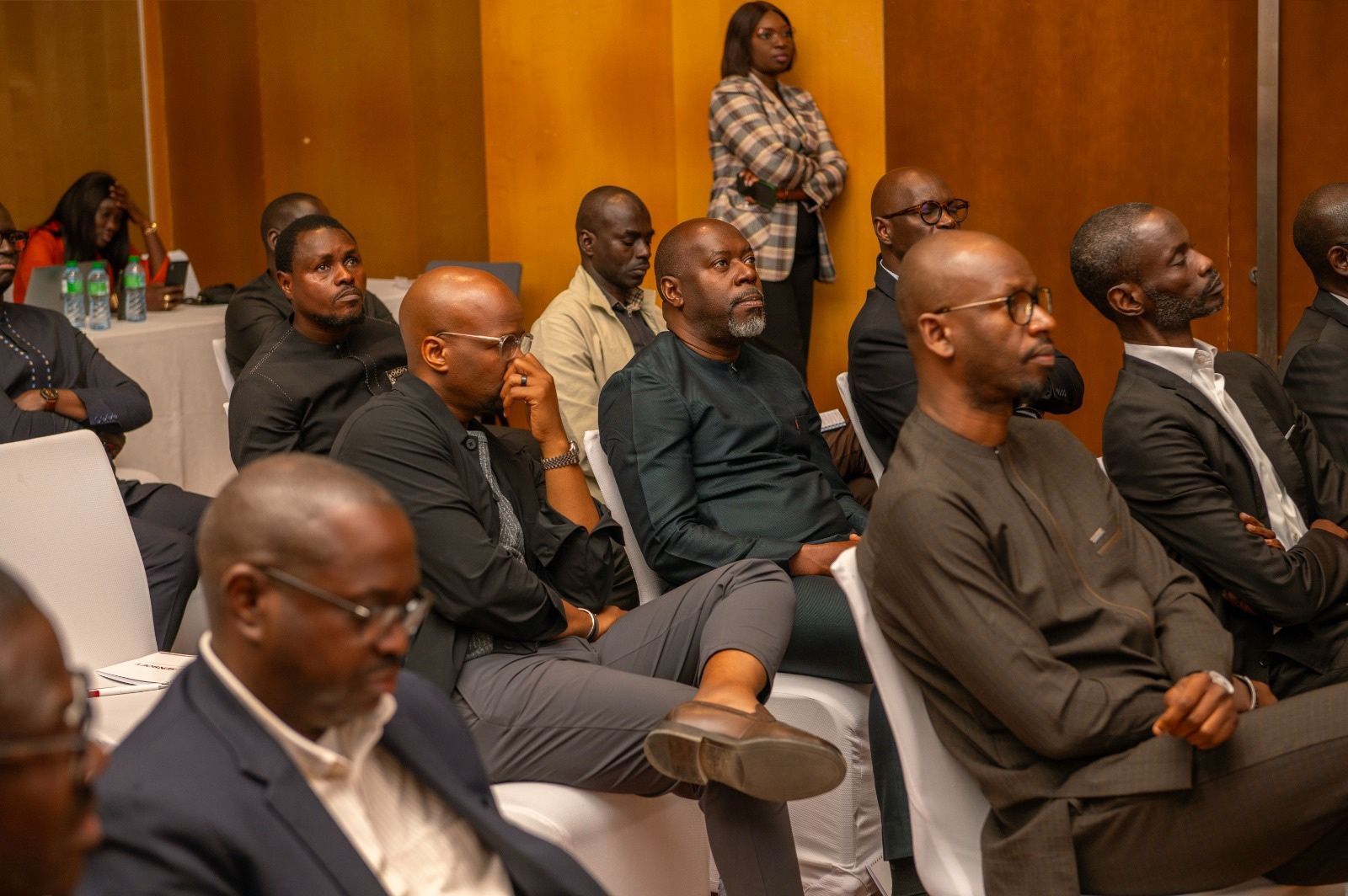 Un groupe d'hommes sont assis sur des chaises et regardent une présentation.