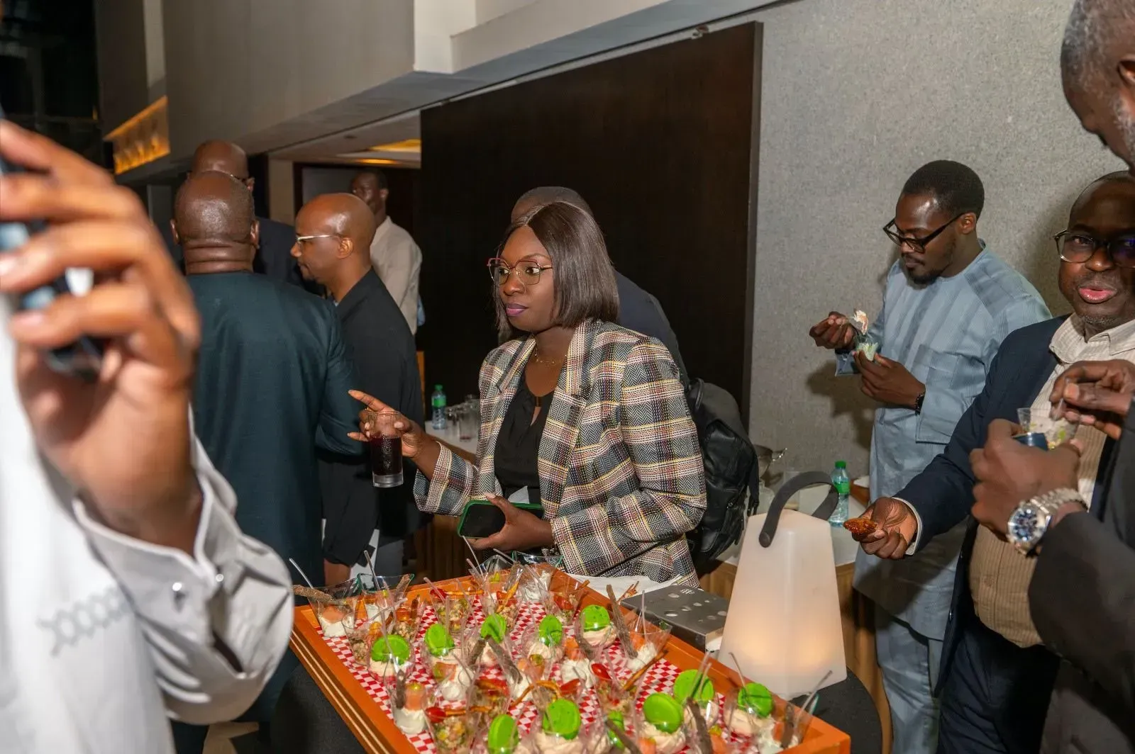 Un groupe de personnes se tient autour d'une table avec de la nourriture dessus.