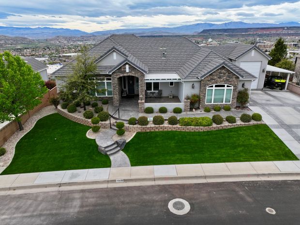 An aerial view of a large house with a lush green lawn.