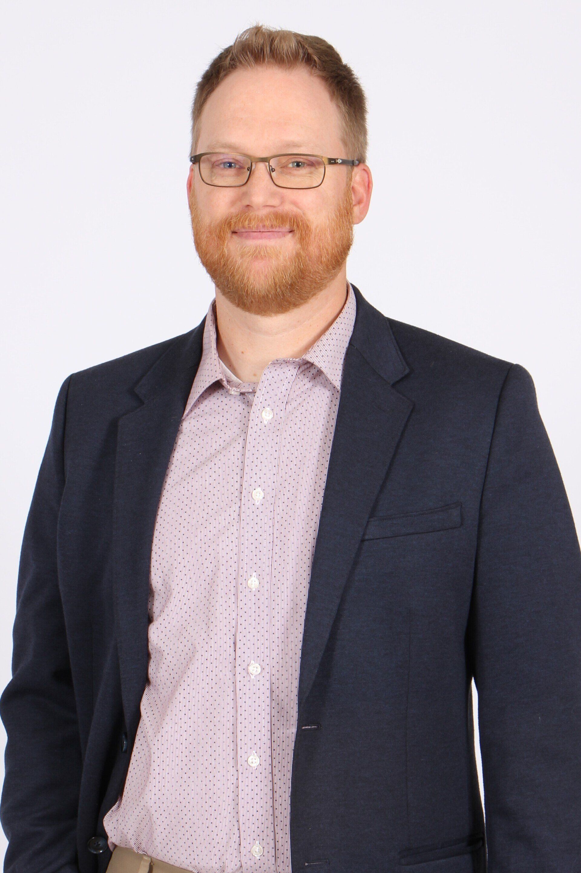 A woman in a pink sweater is smiling for the camera.