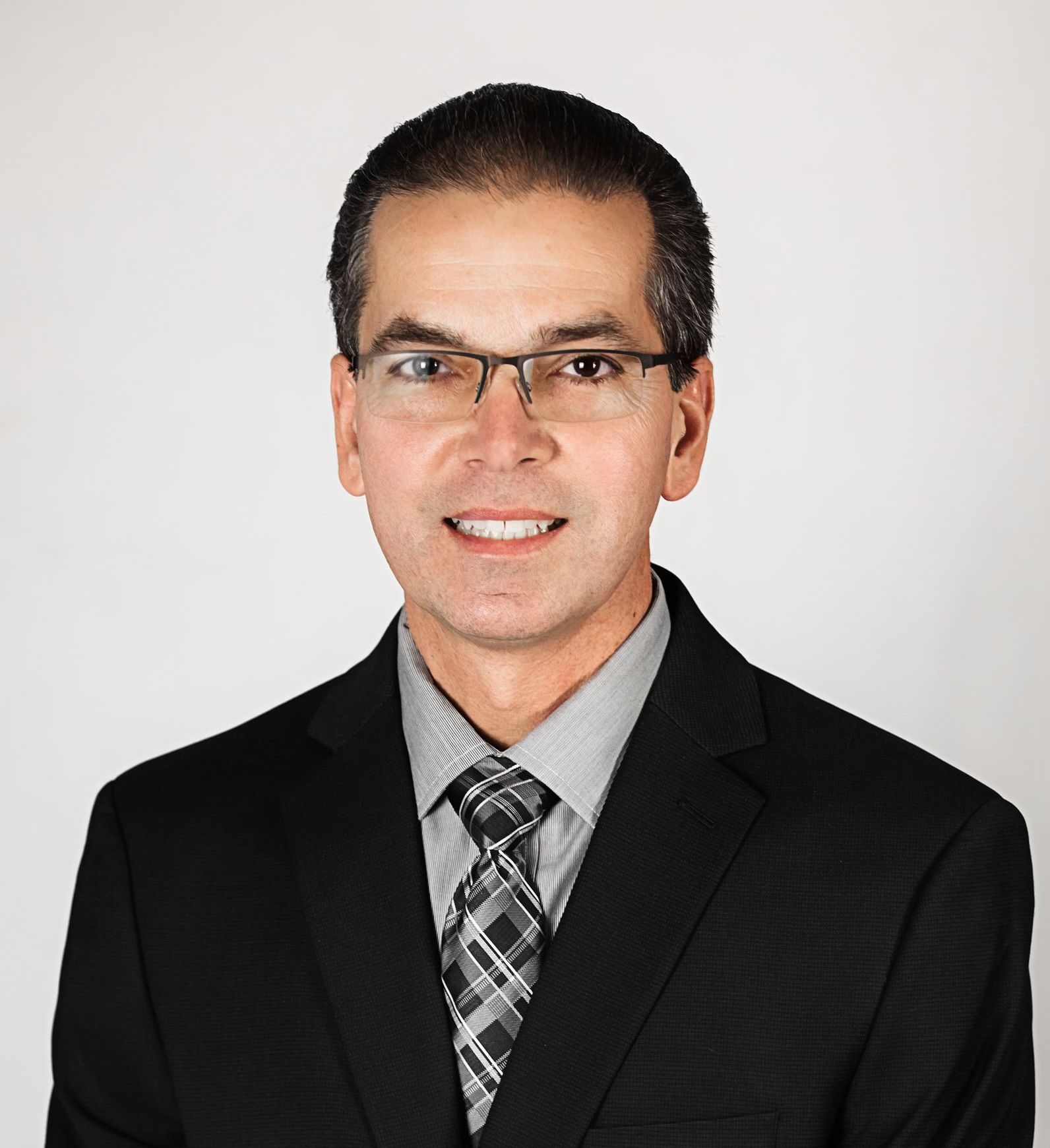 A man in a suit and tie is smiling for the camera