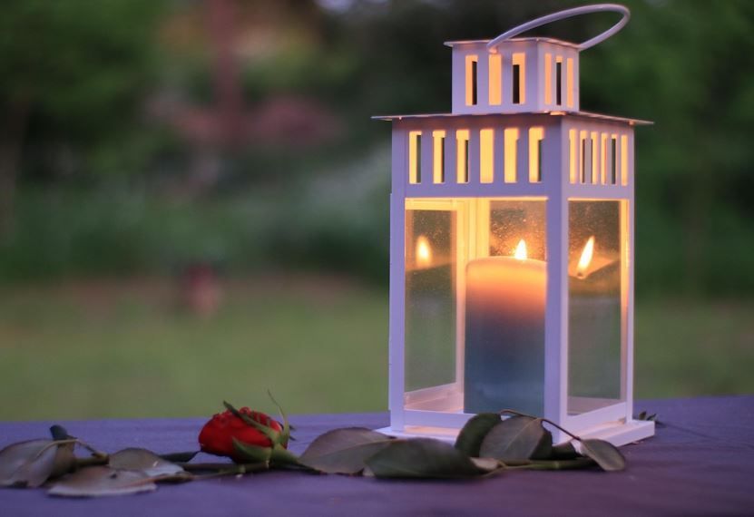 Memorial lantern with burning candle and red rose at dusk, funeral homes Bonaire, GA